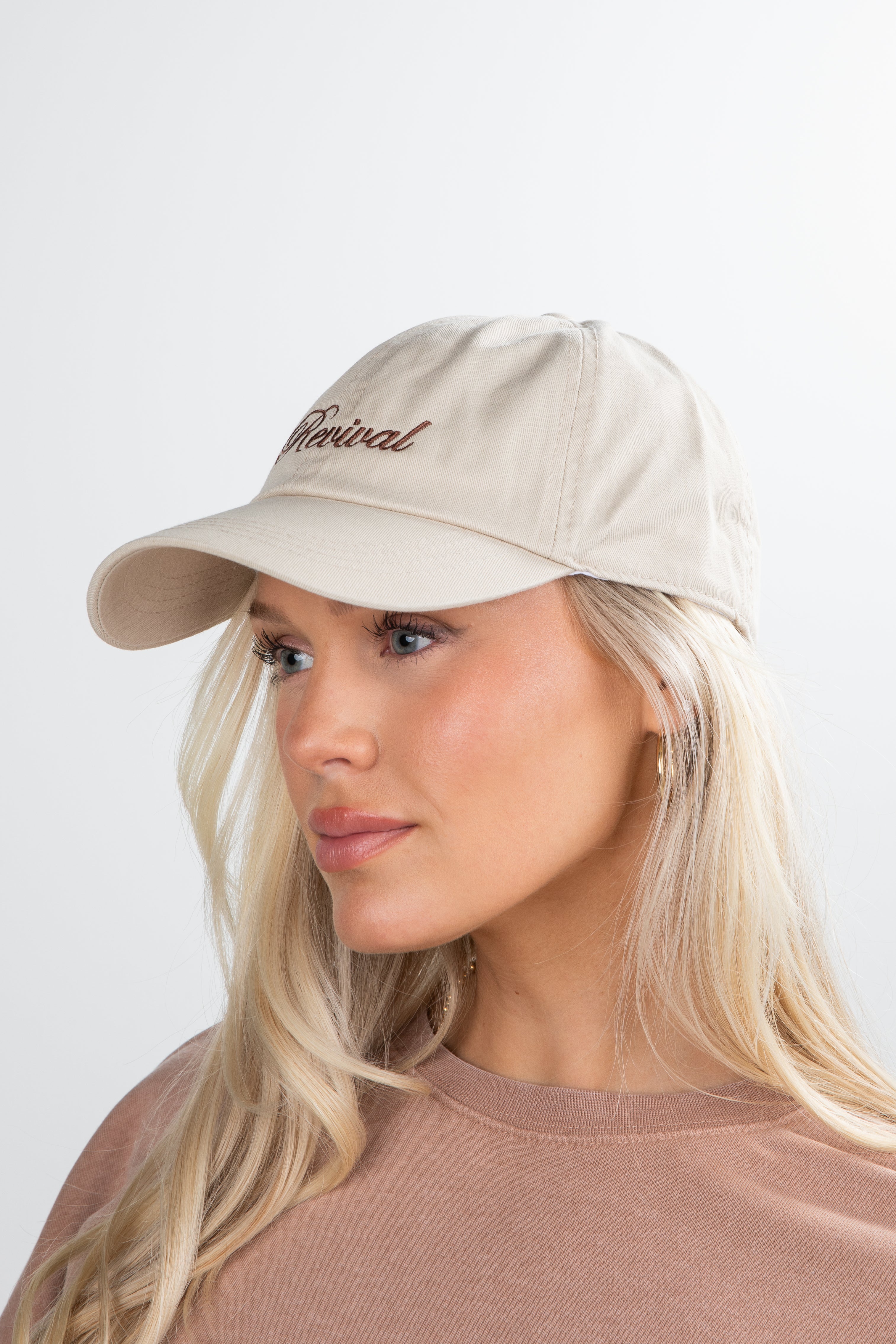 Woman wearing a beige cap with &