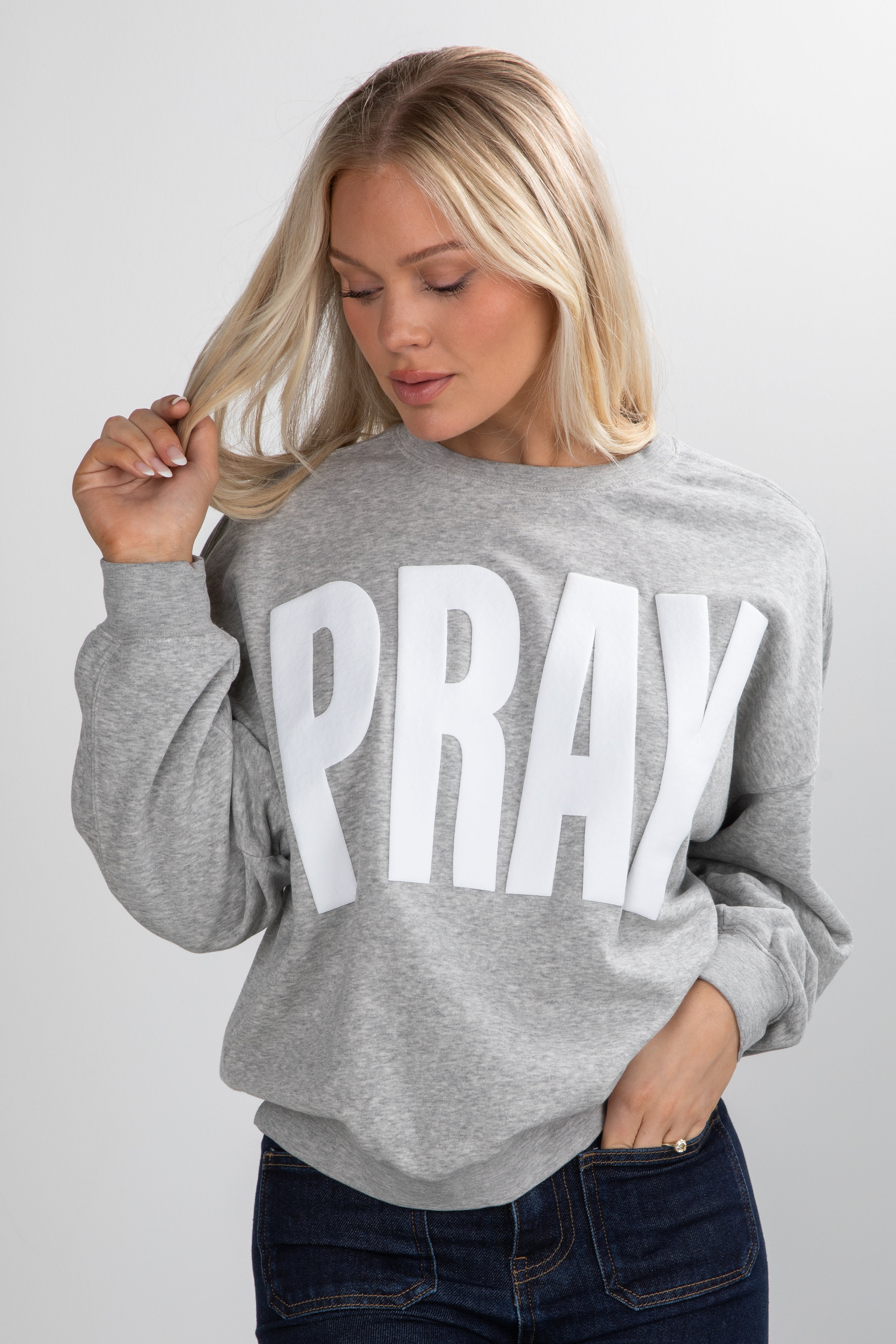 Woman wearing a gray sweatshirt with &