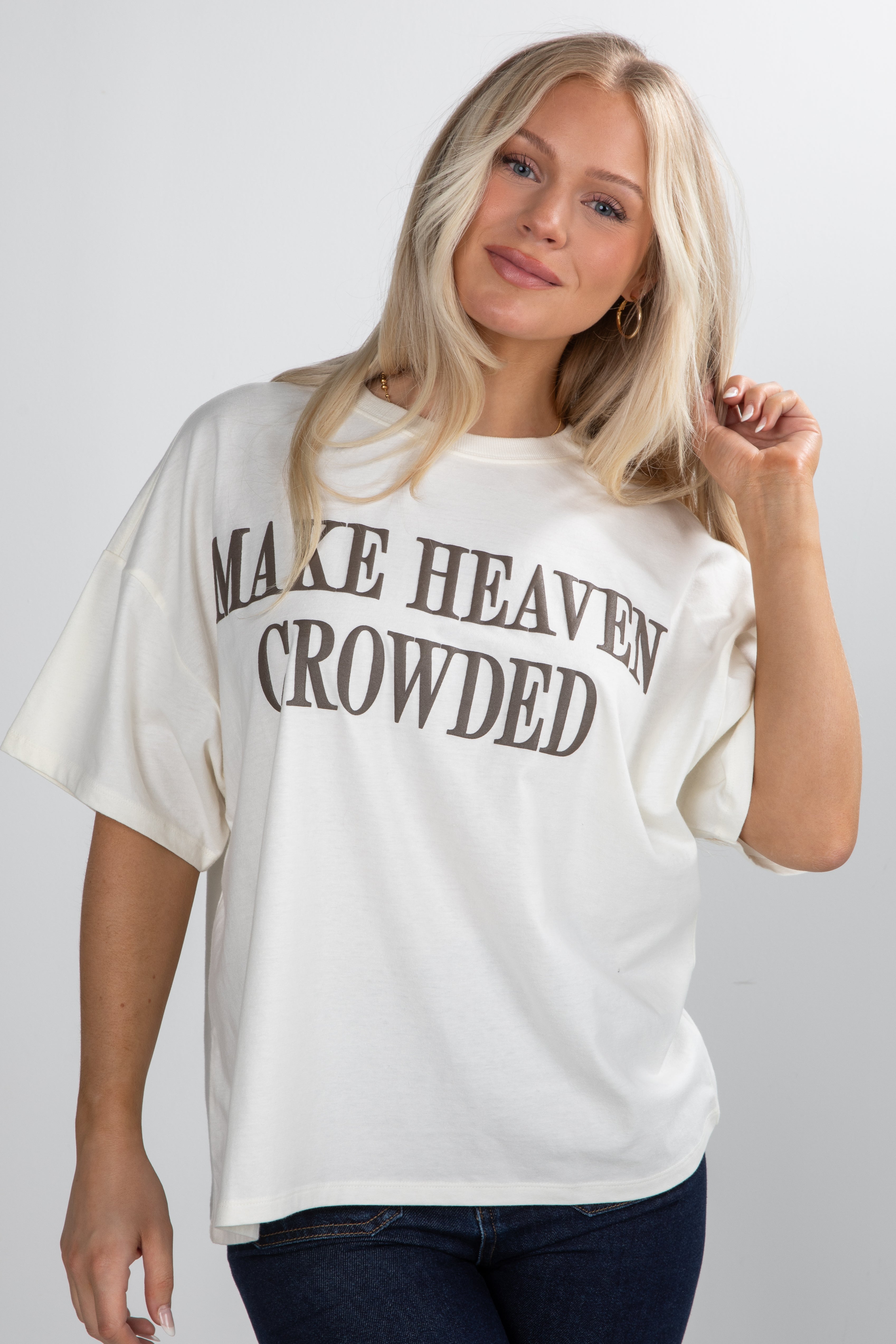 Woman wearing a white t-shirt with text on a plain background