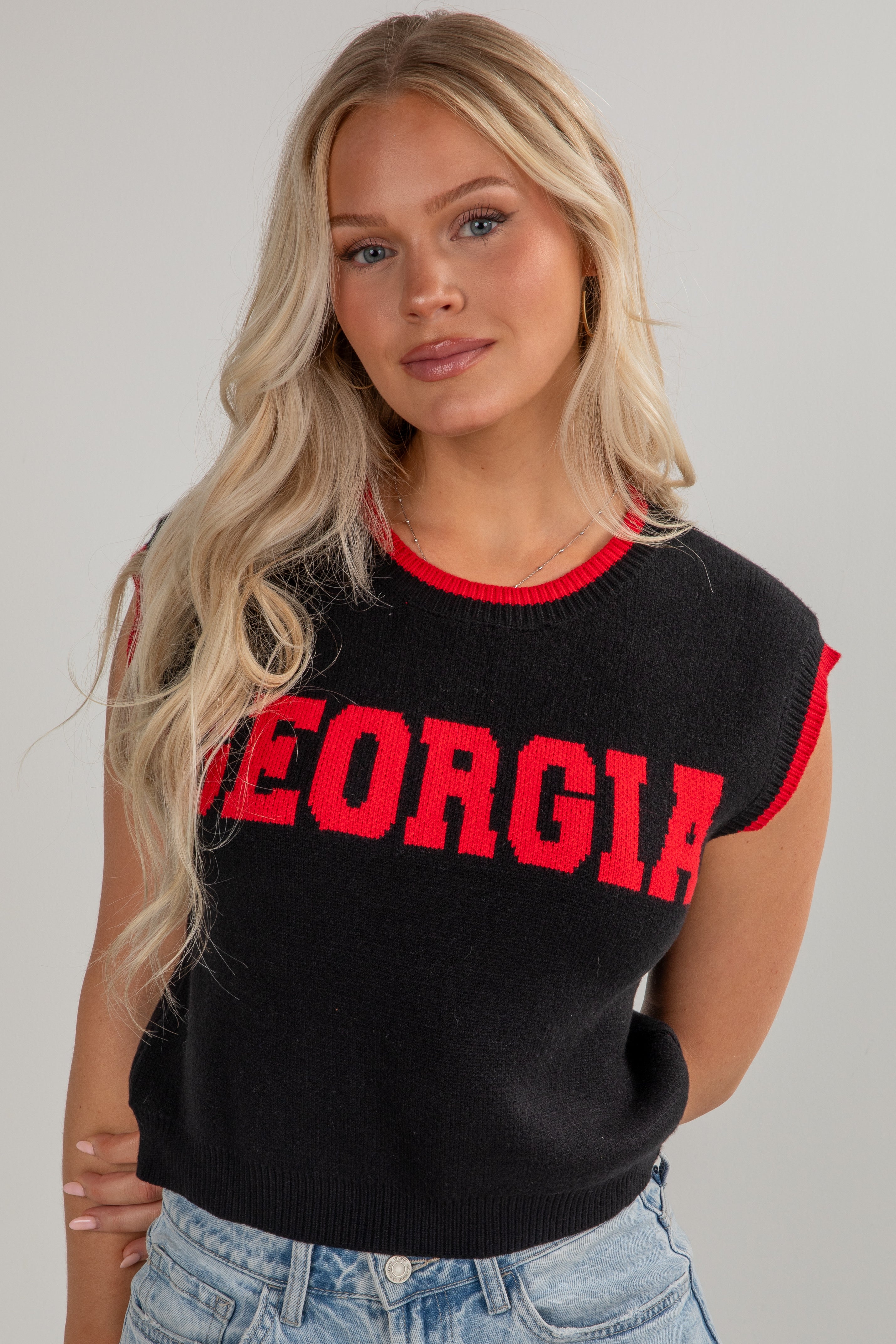 Woman wearing a black sleeveless top with &