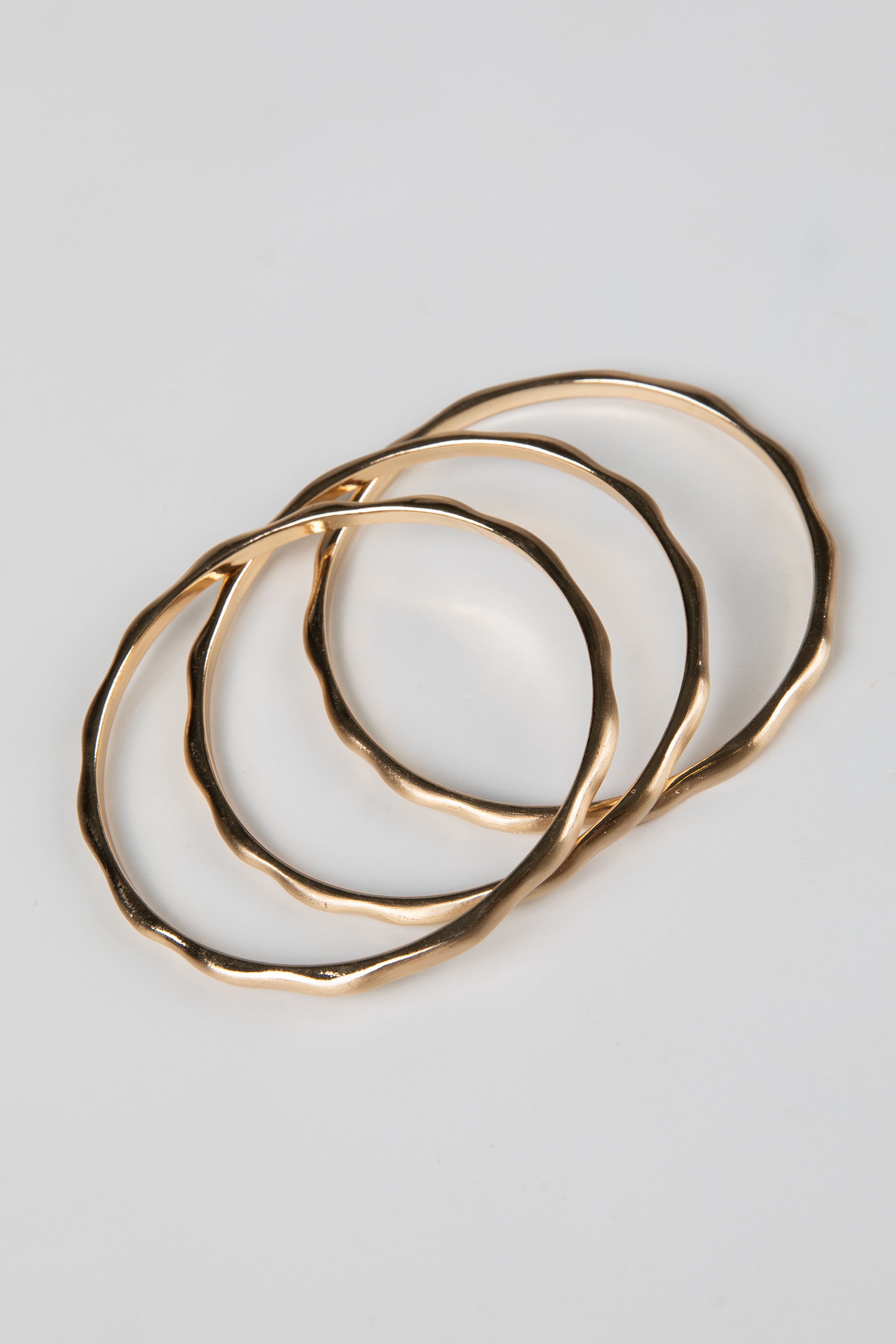 Set of gold hoop earrings on a light gray background