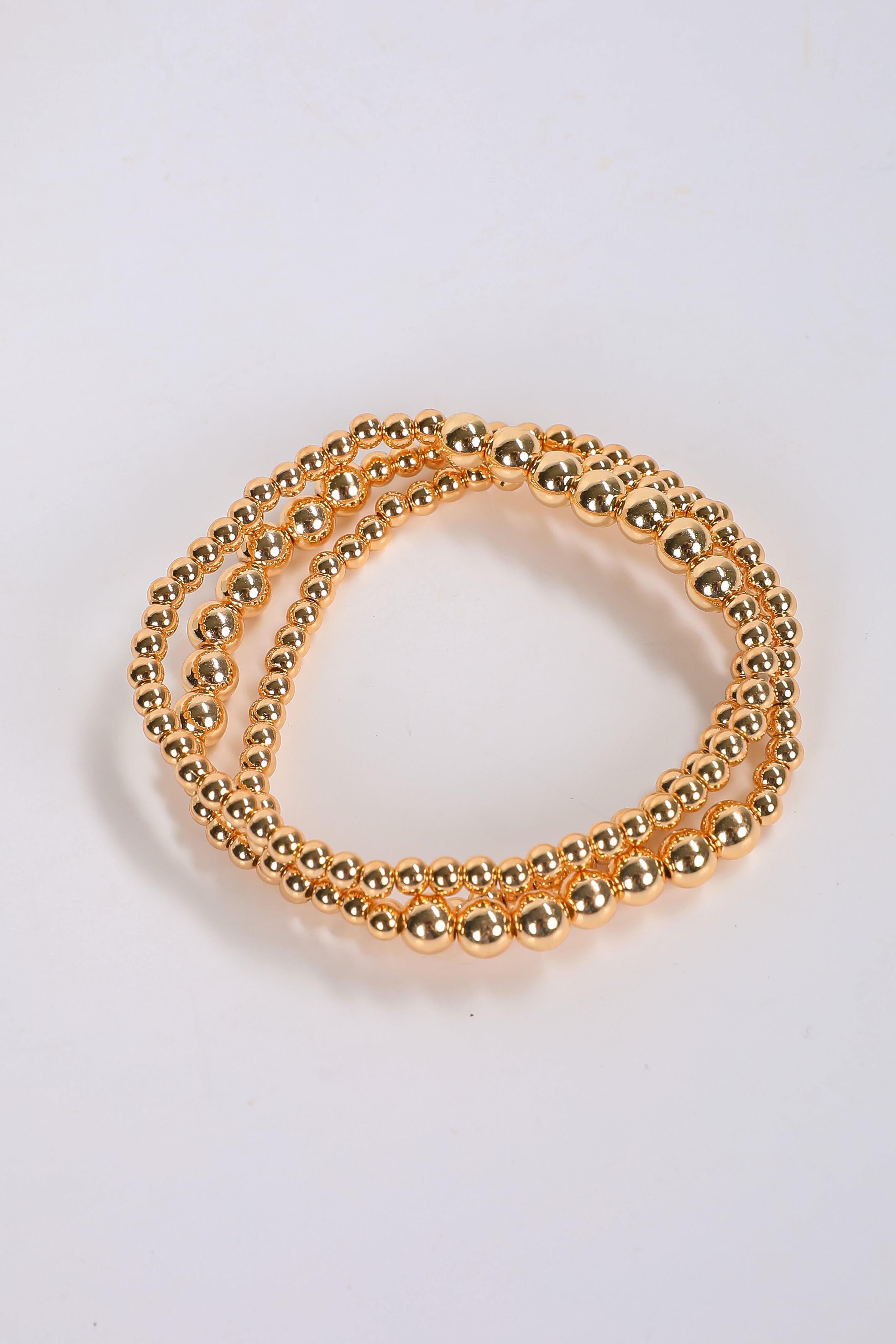 Gold beaded bracelet on a white background