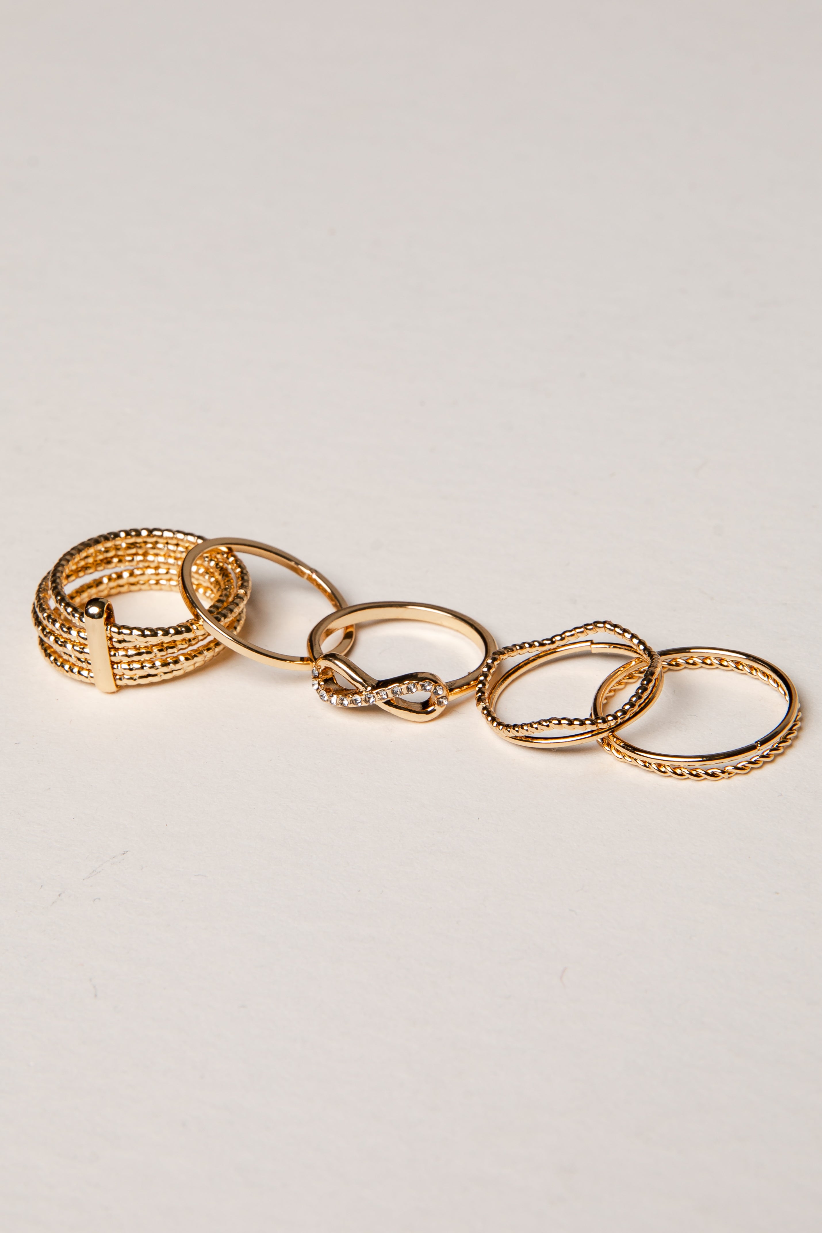 Set of gold rings on a light gray background