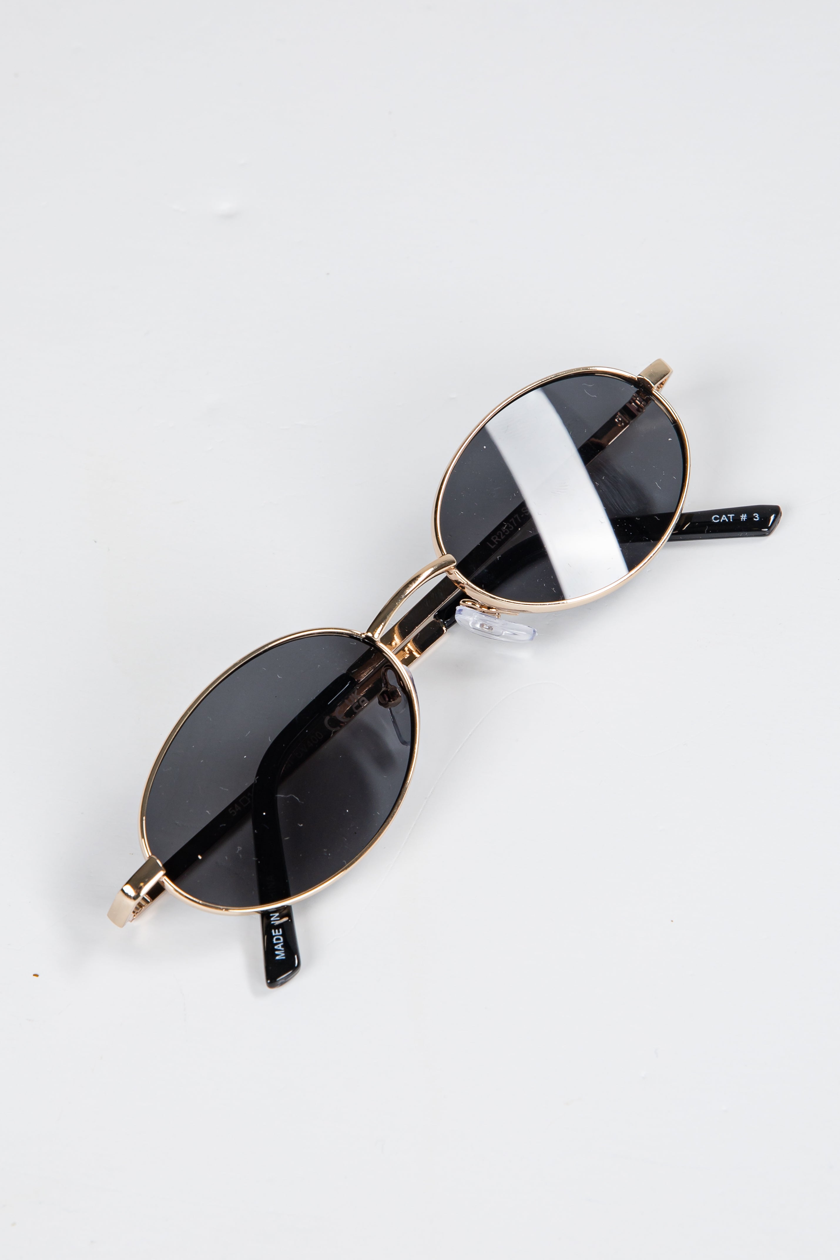 Sunglasses with gold frames and black lenses on a white background