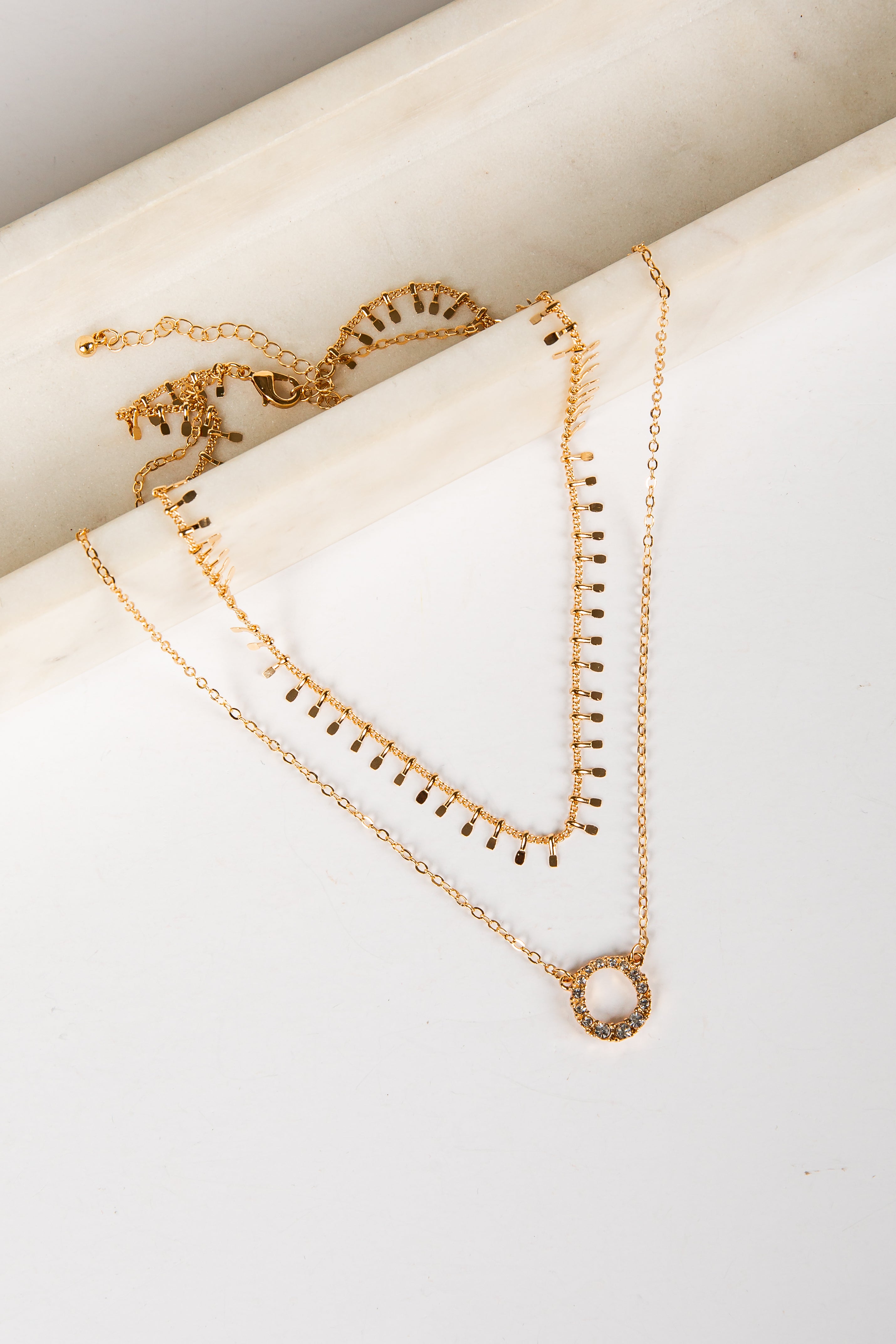 Gold necklaces on a white surface