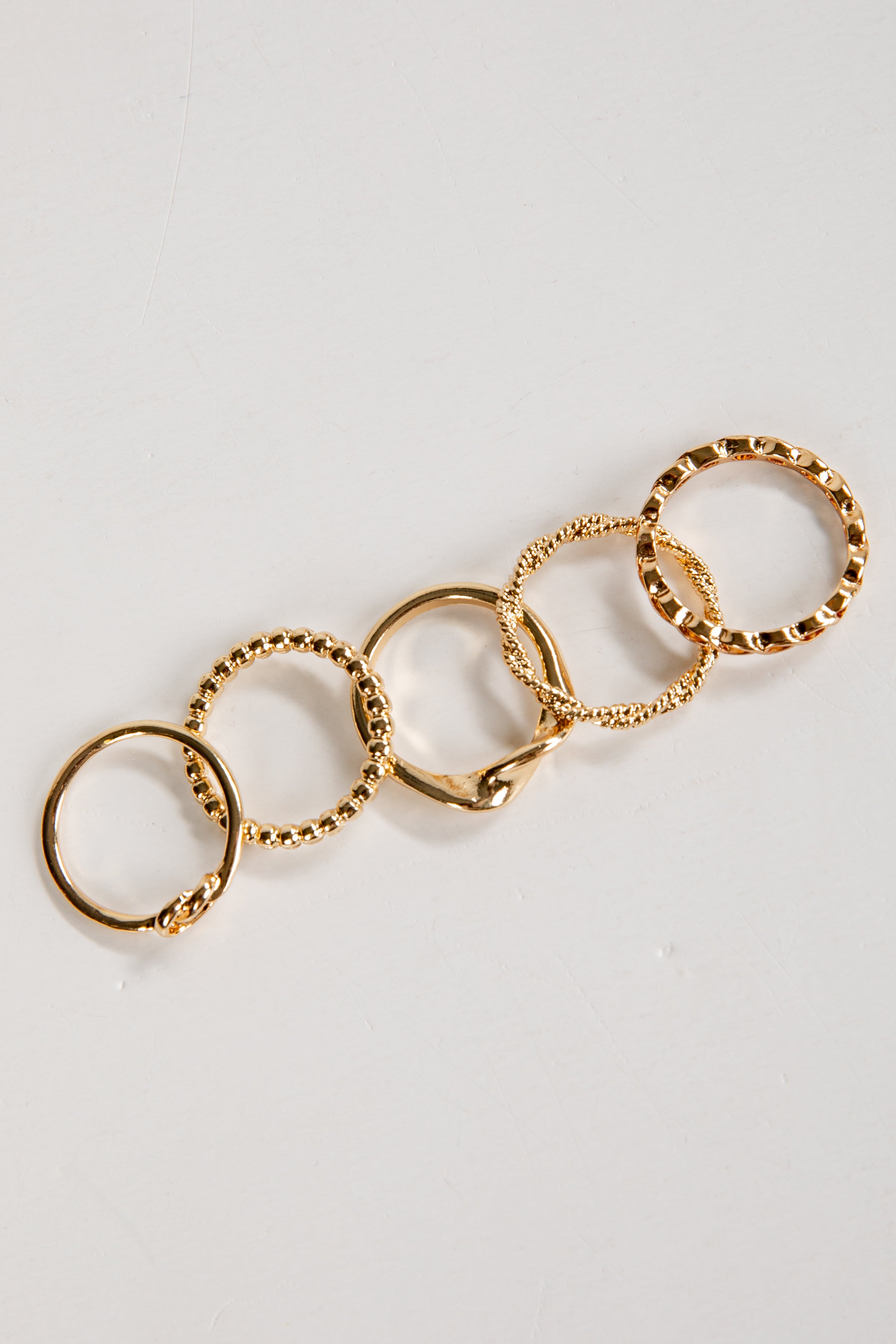 Gold ring with multiple interconnected rings on a light gray background