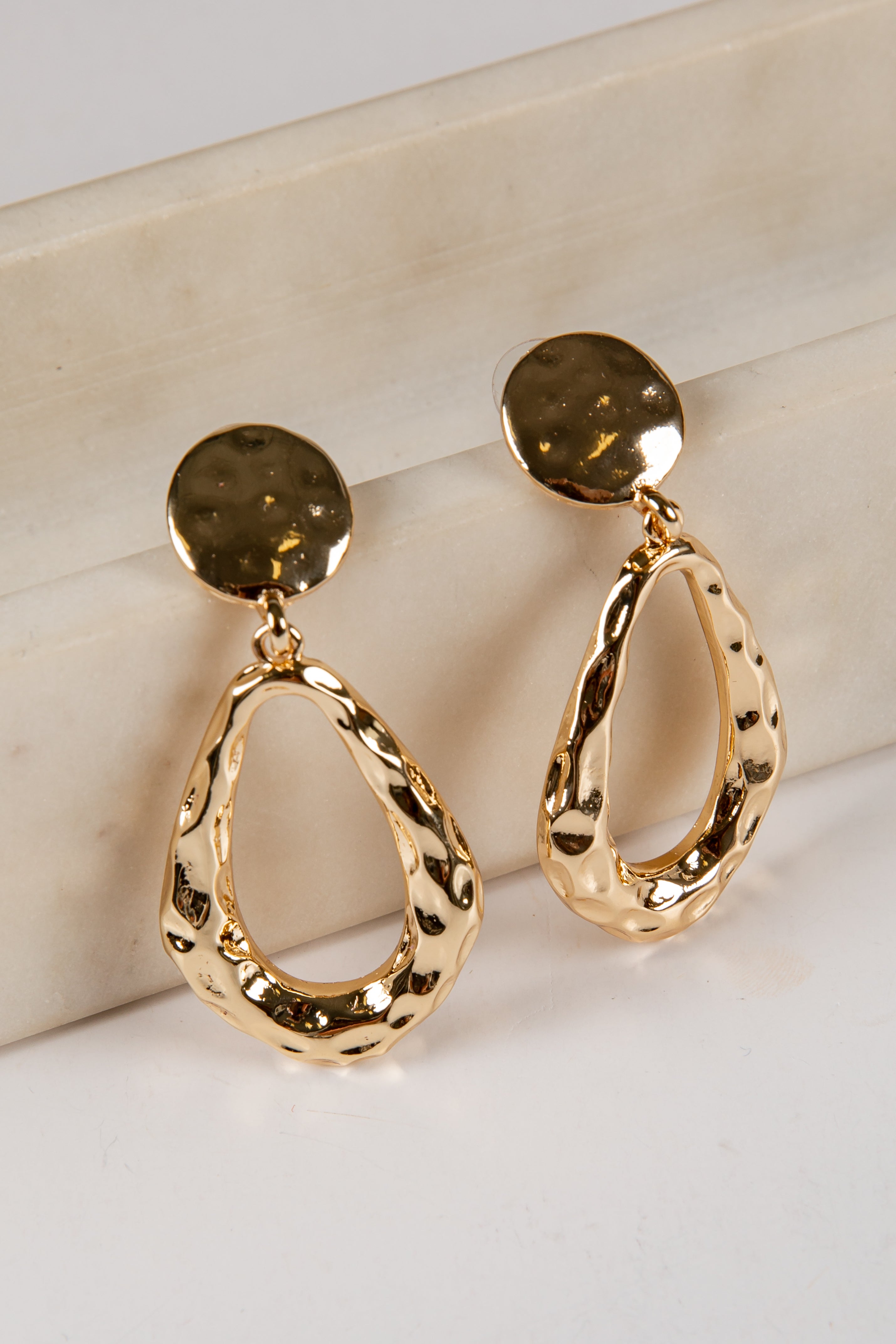 Gold hoop earrings on a light background