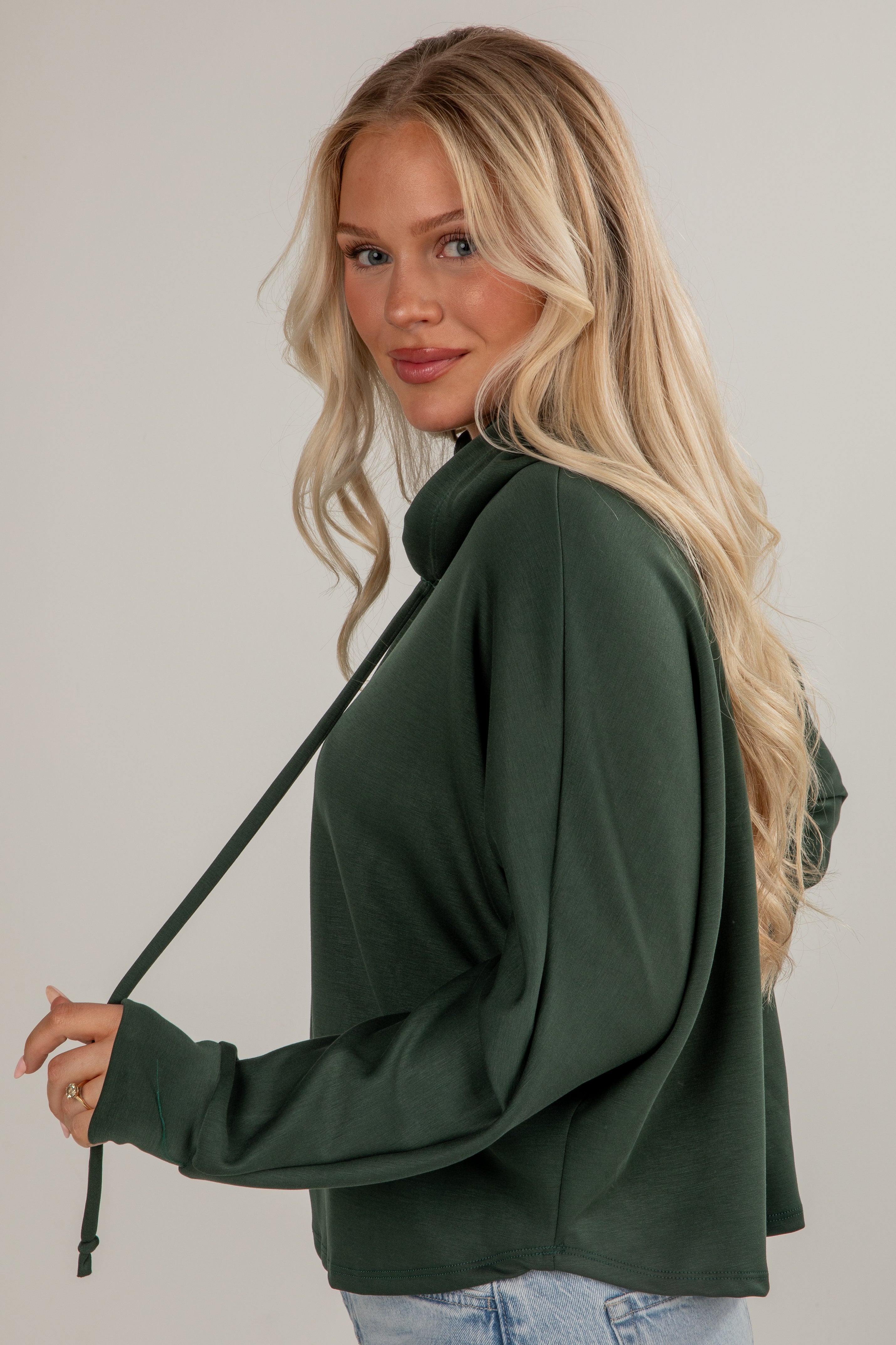 Woman wearing a green sweater with a neutral background