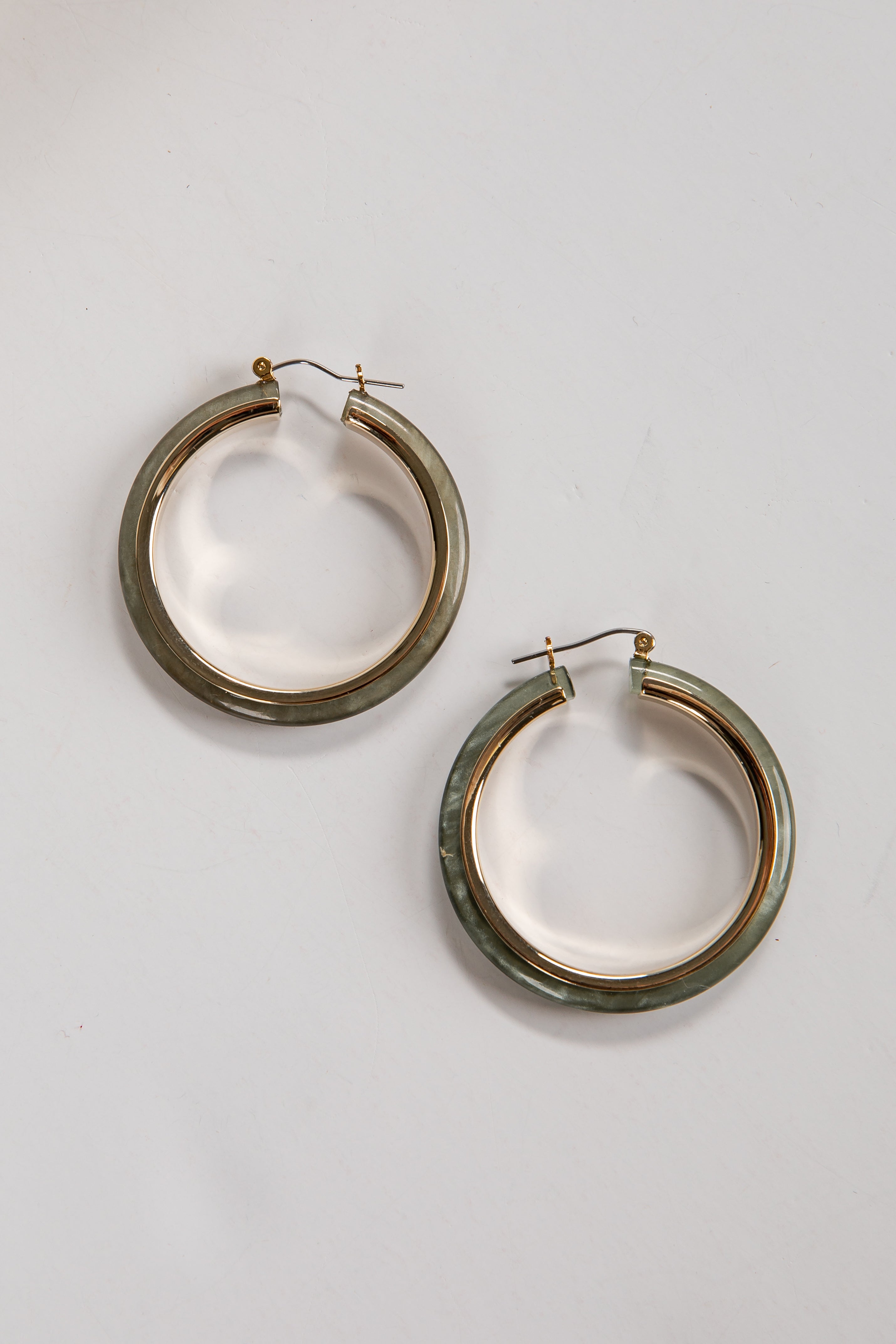 Pair of gold hoop earrings on a light gray background