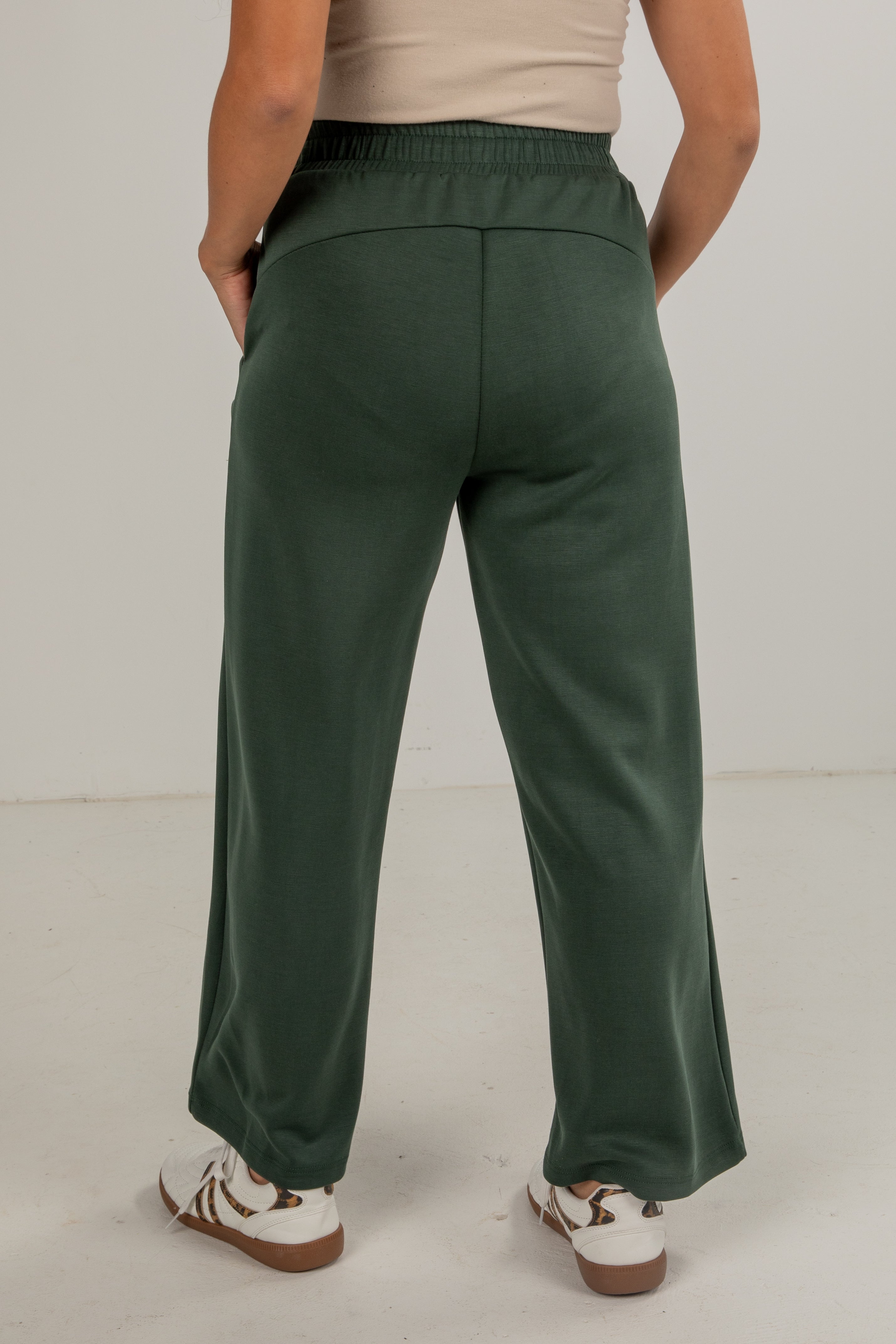 Person wearing green pants on a plain background