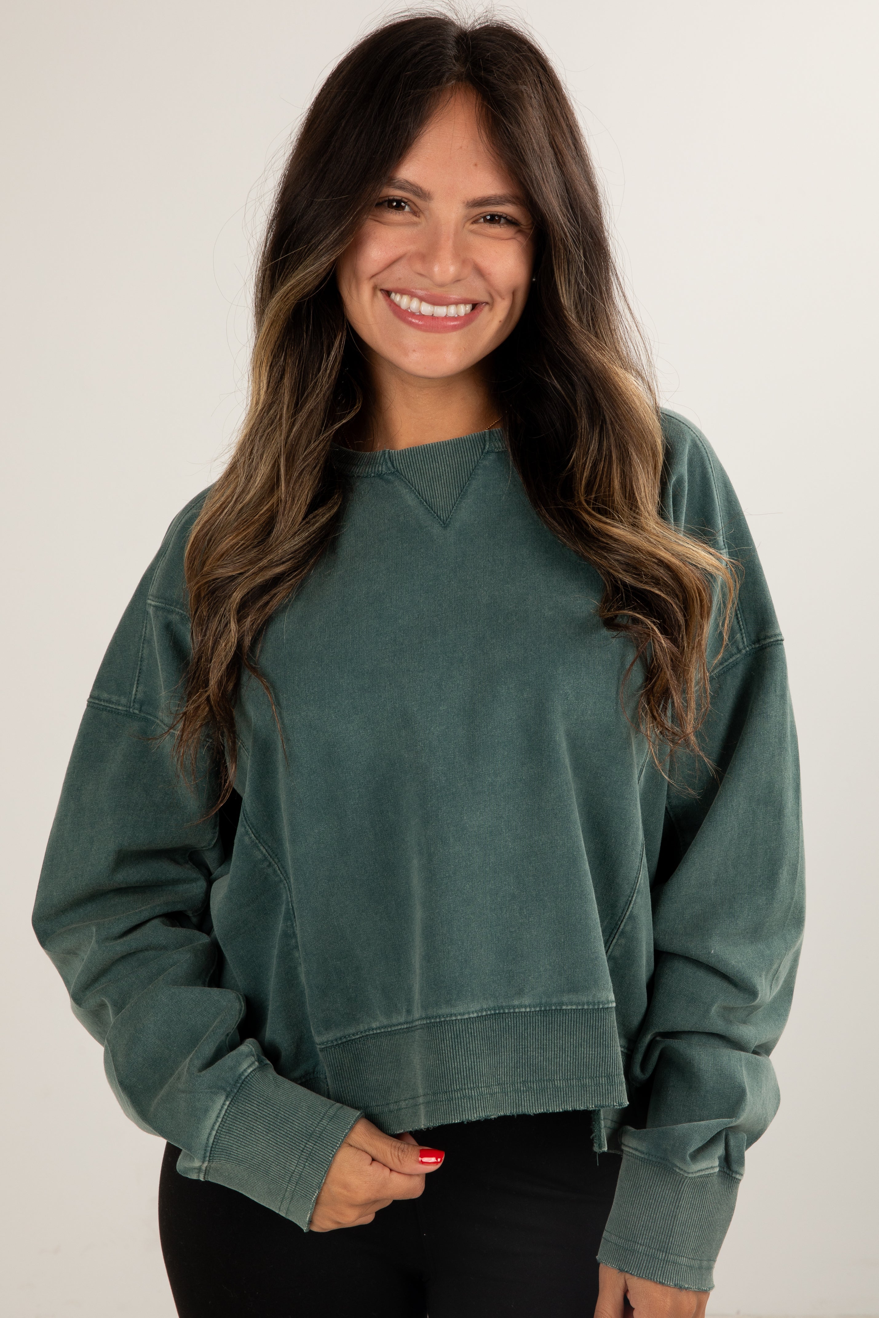 Woman wearing a green sweatshirt against a white background