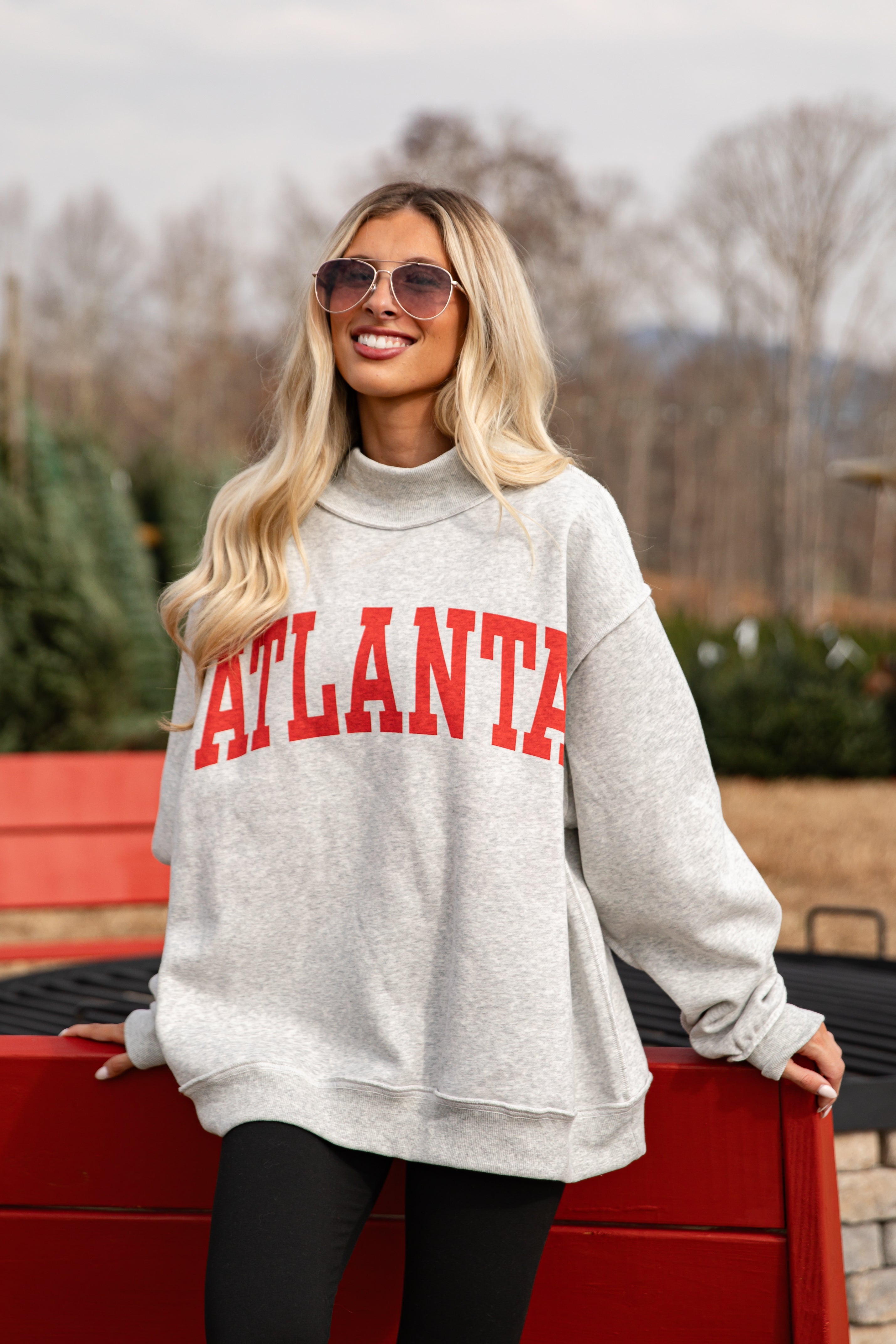Woman wearing a gray sweatshirt with &
