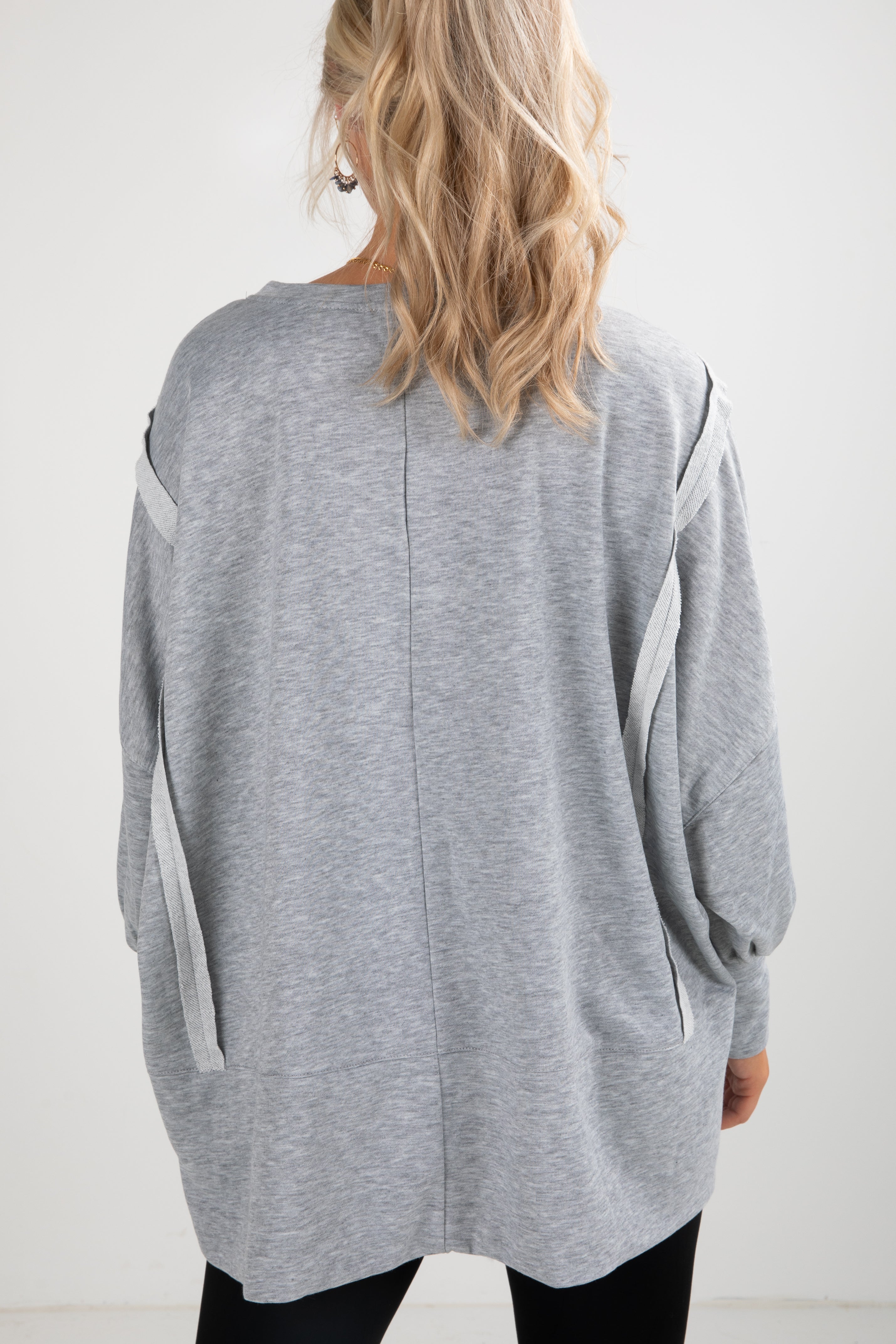 Gray cardigan worn by a person on a white background