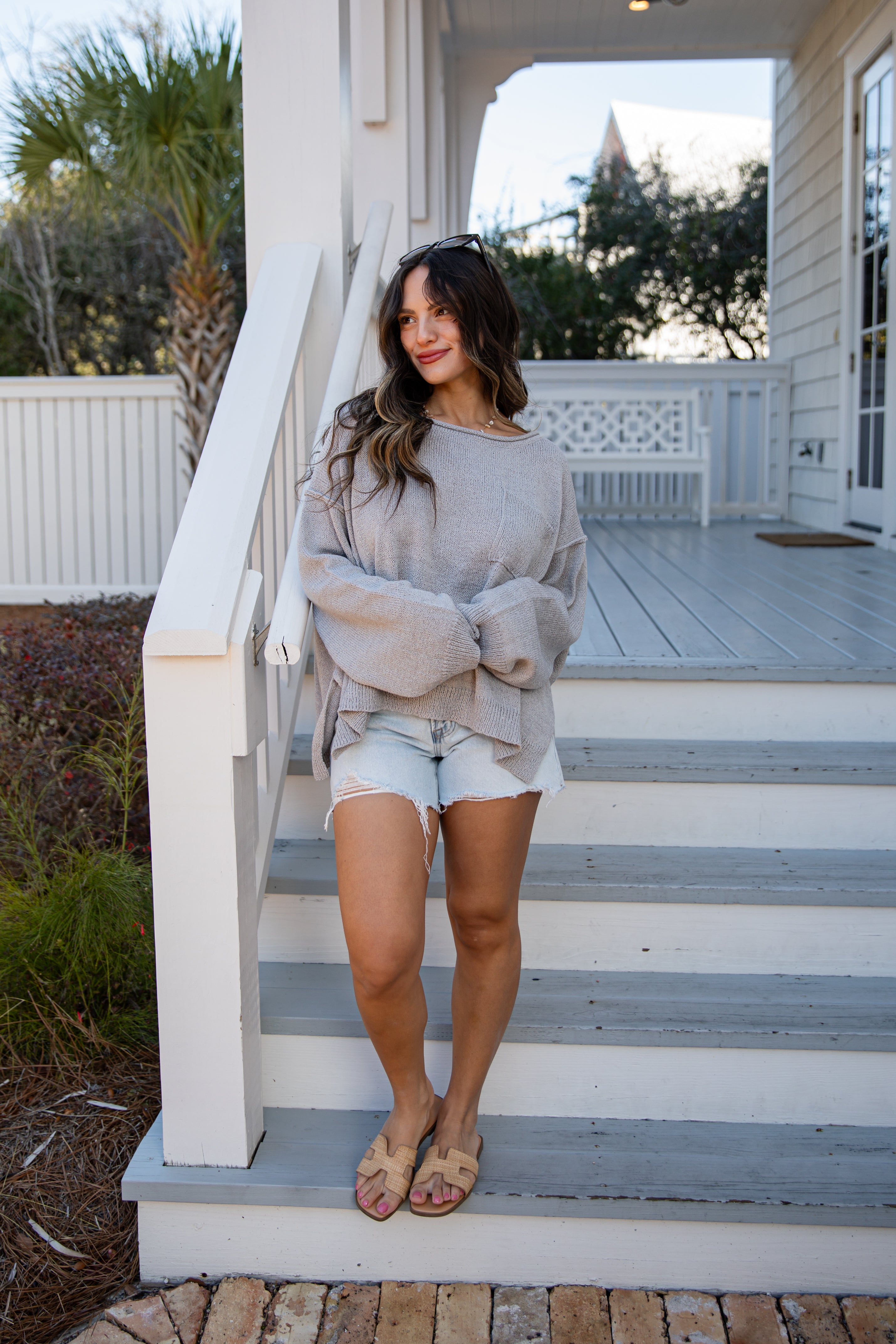 Woman standing on a set of stairs in front of a house