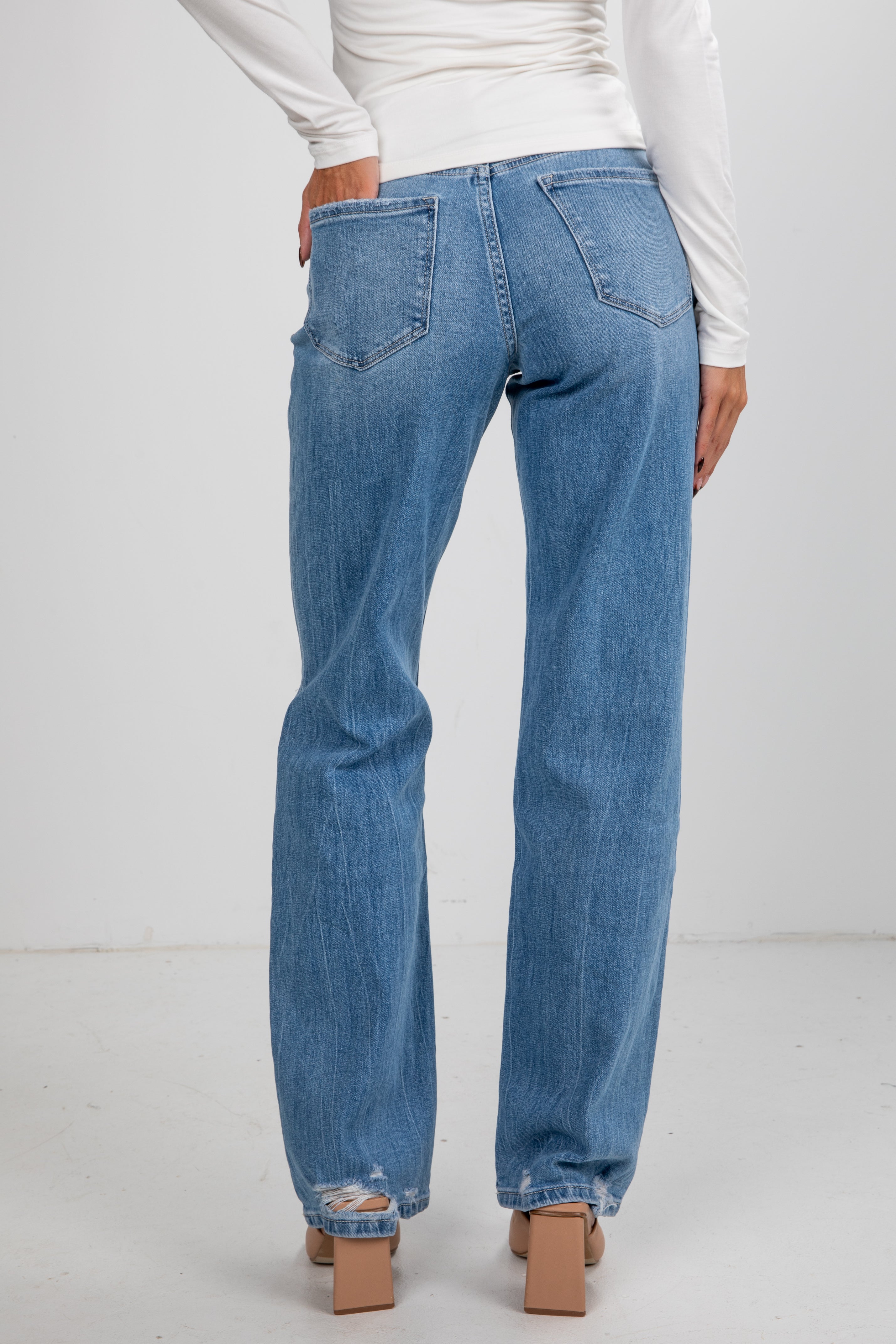 Blue jeans worn by a person on a white background