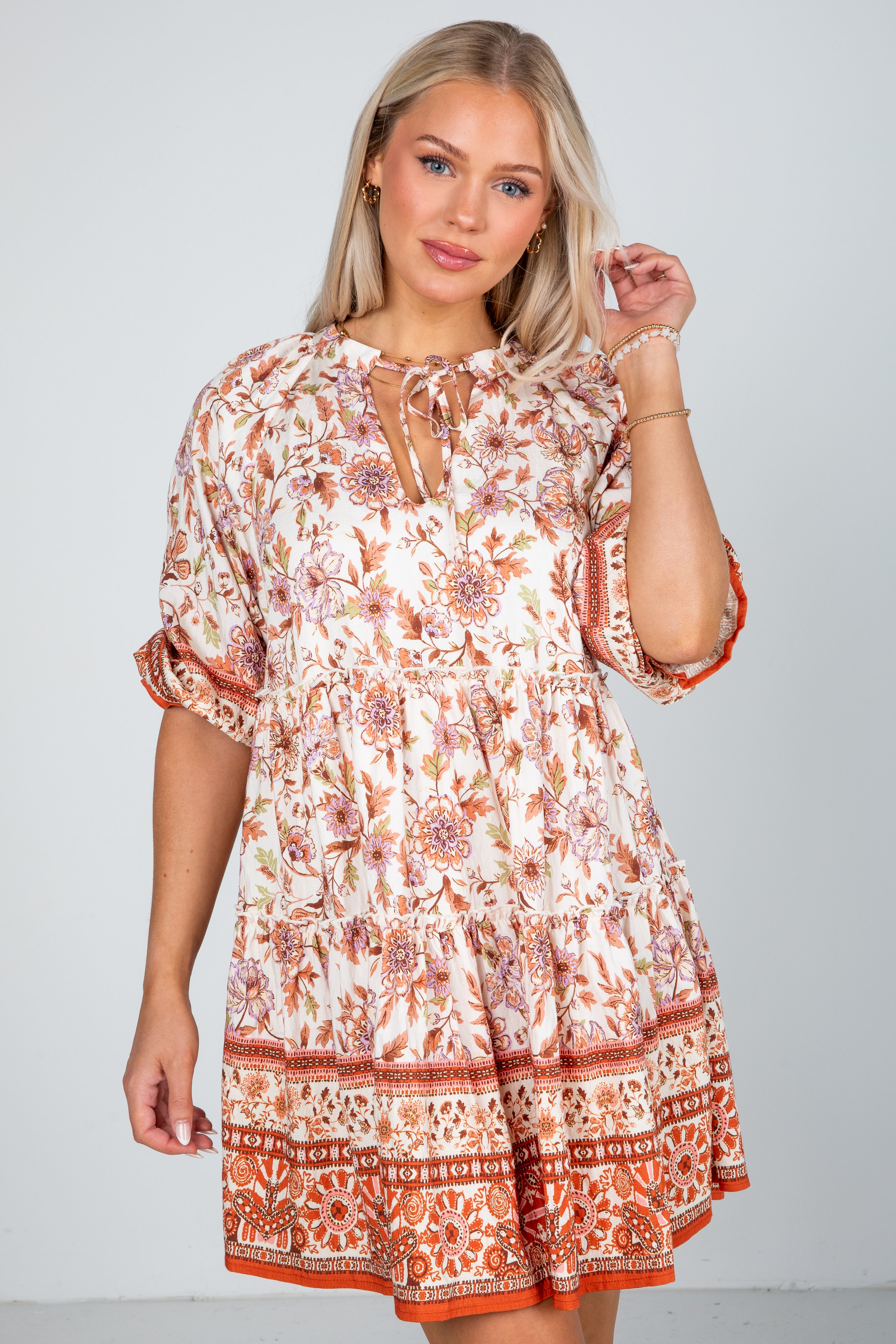 Woman wearing a patterned dress against a plain background