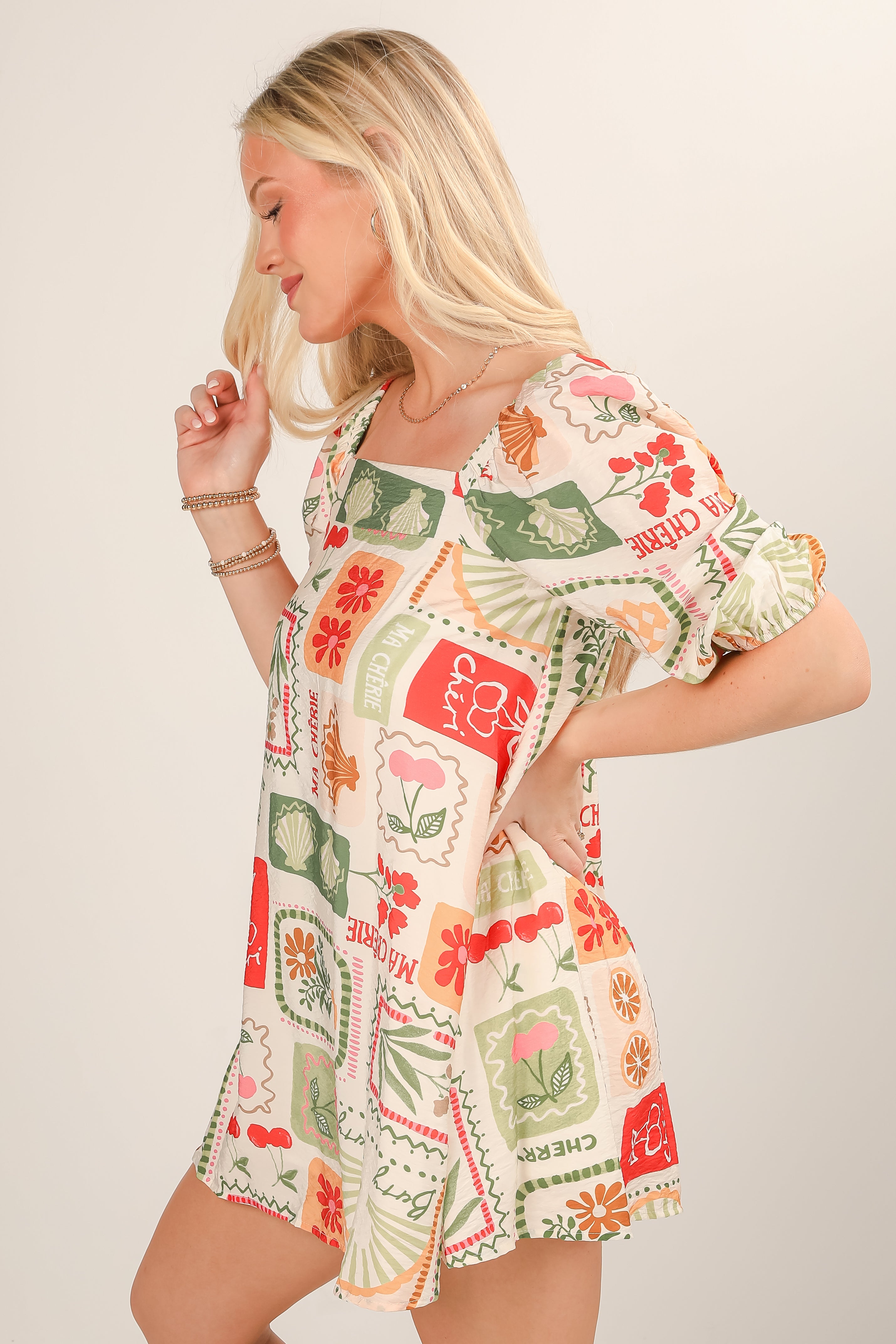 Woman wearing a colorful patterned dress on a plain background