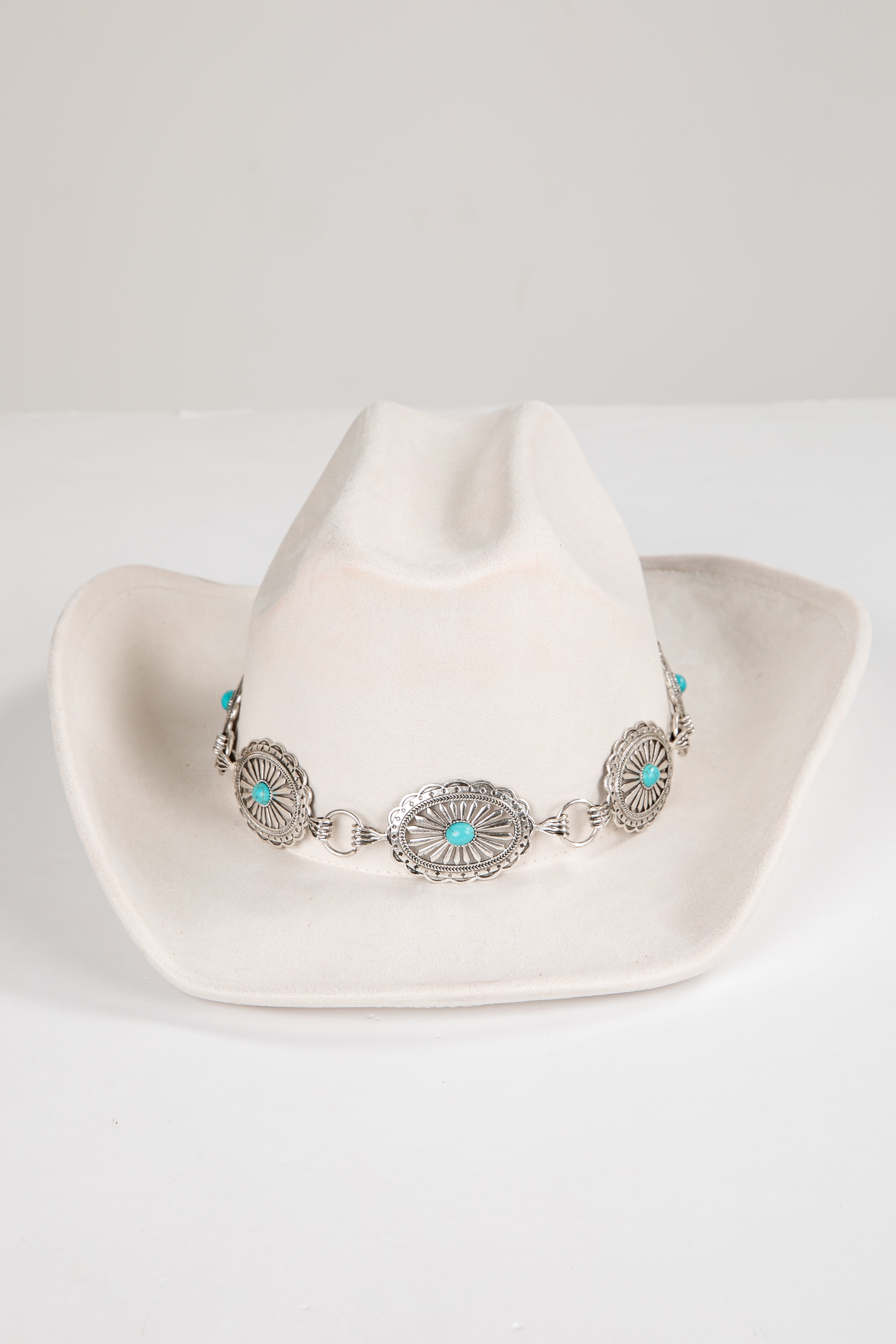 White cowboy hat with a decorative band featuring turquoise stones on a white background