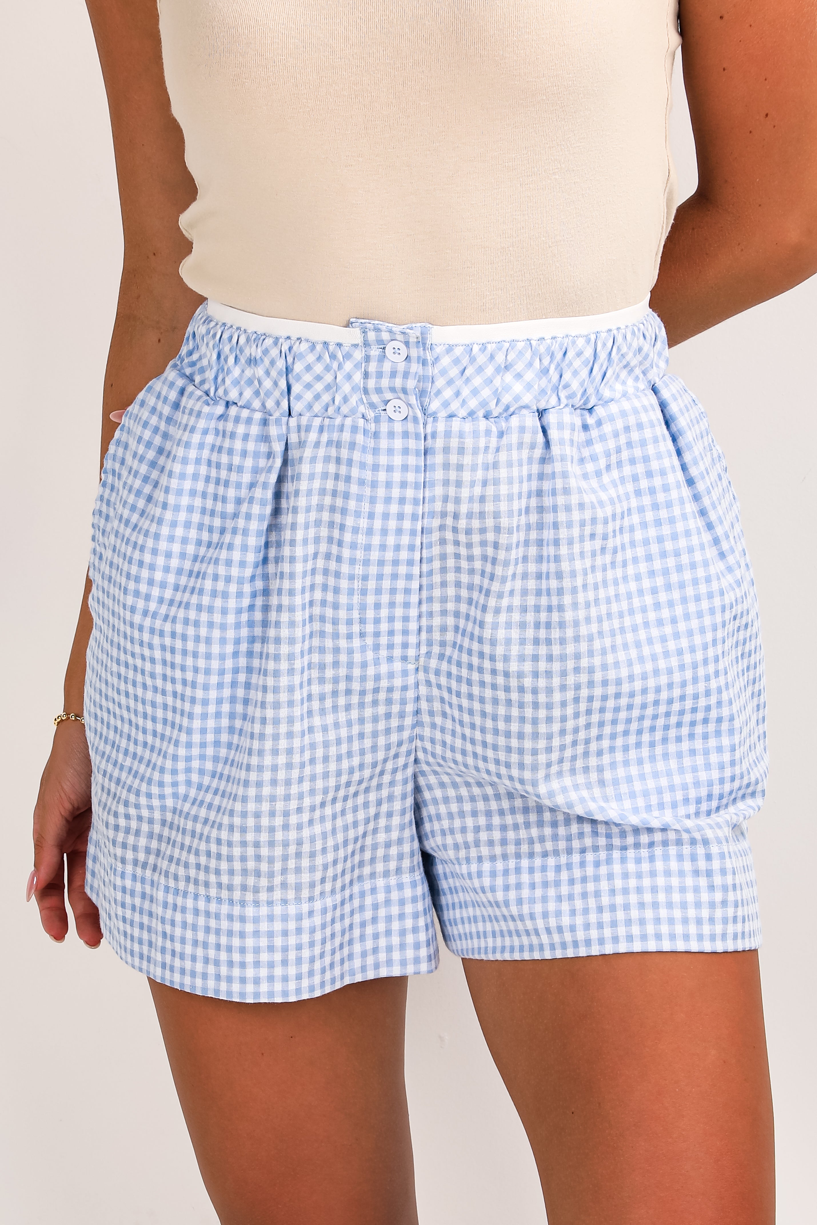 Light blue checkered shorts worn by a person on a plain background