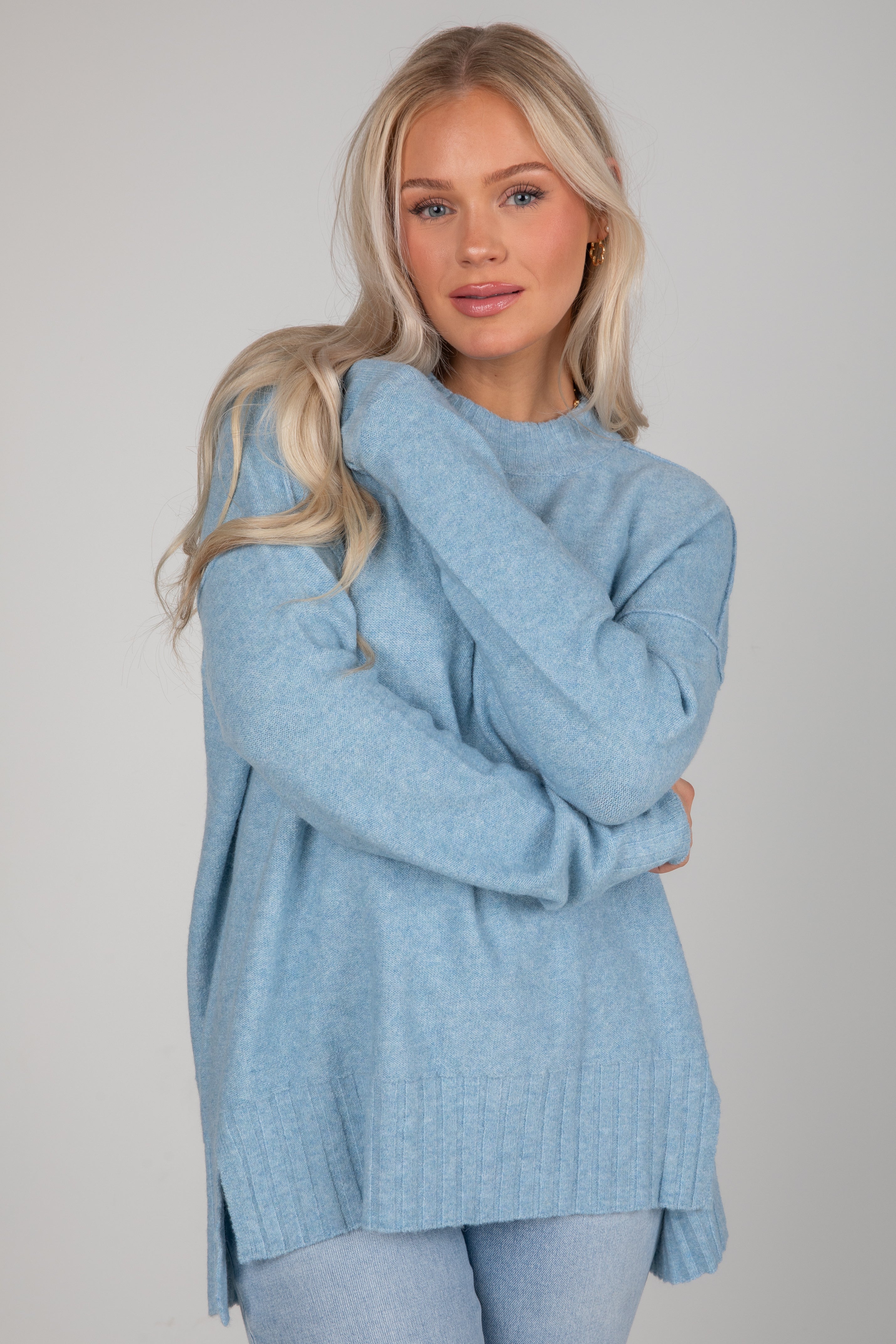 Woman wearing a light blue sweater against a plain background