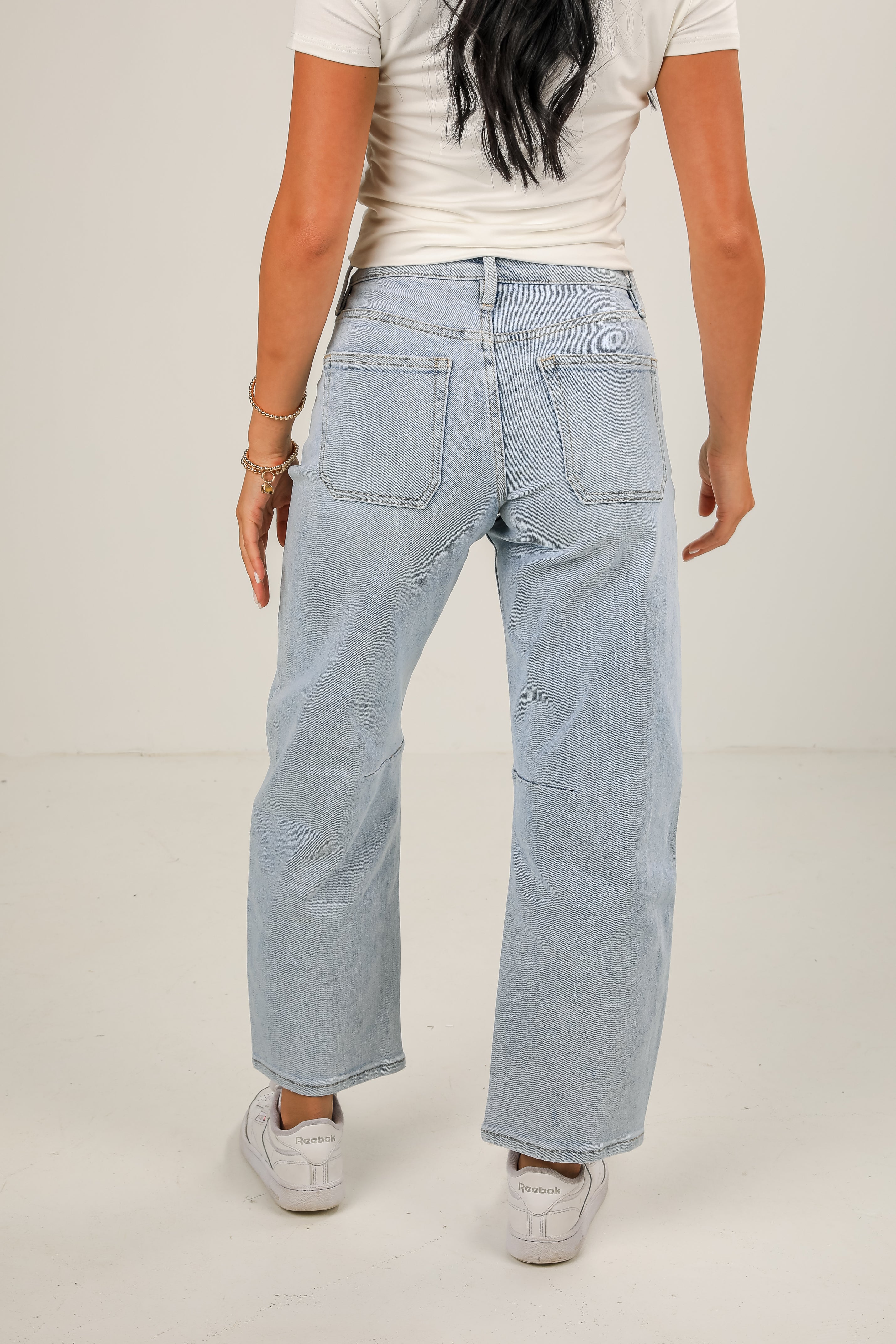 Light blue jeans worn by a person on a plain background