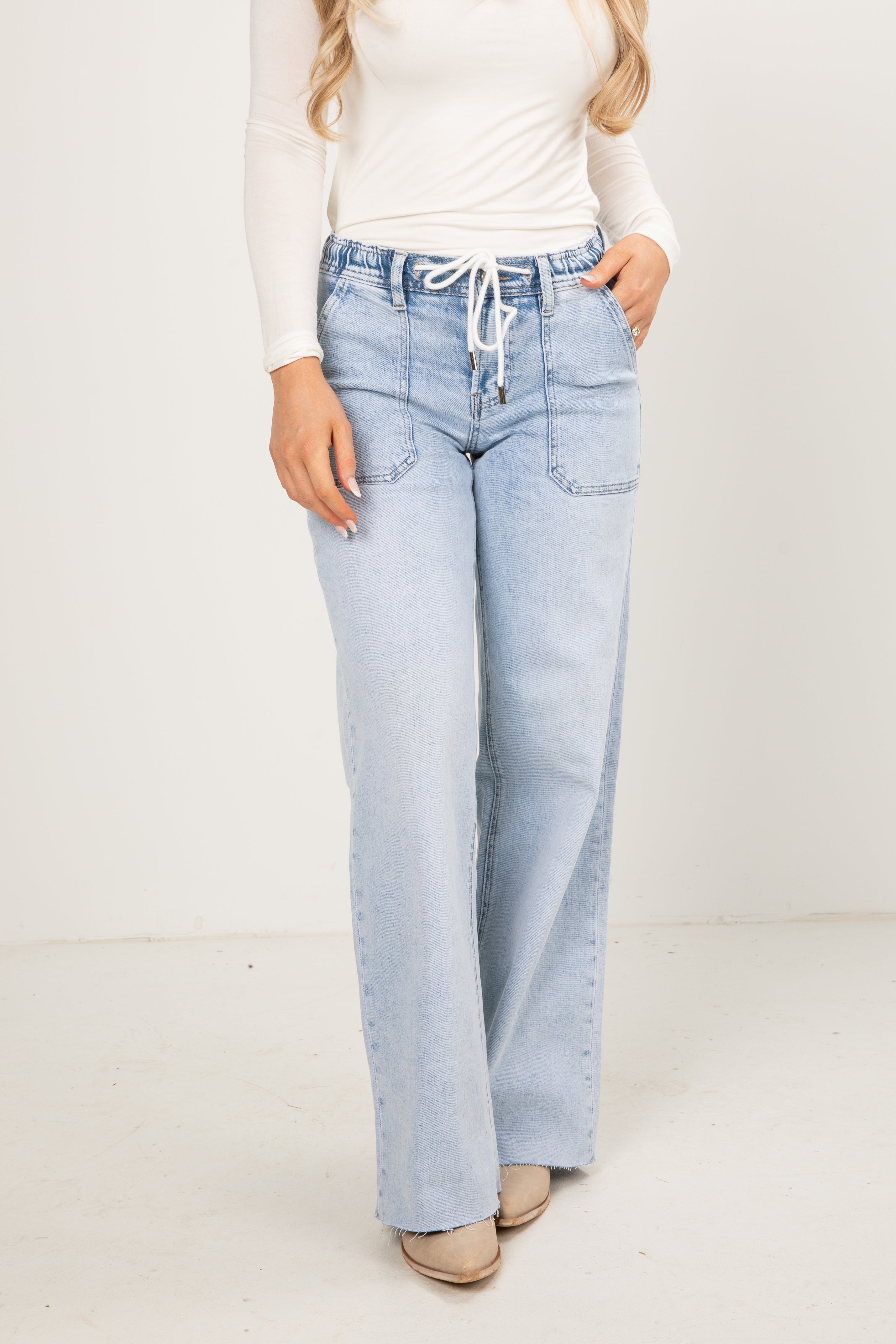 Light blue jeans worn by a person on a white background