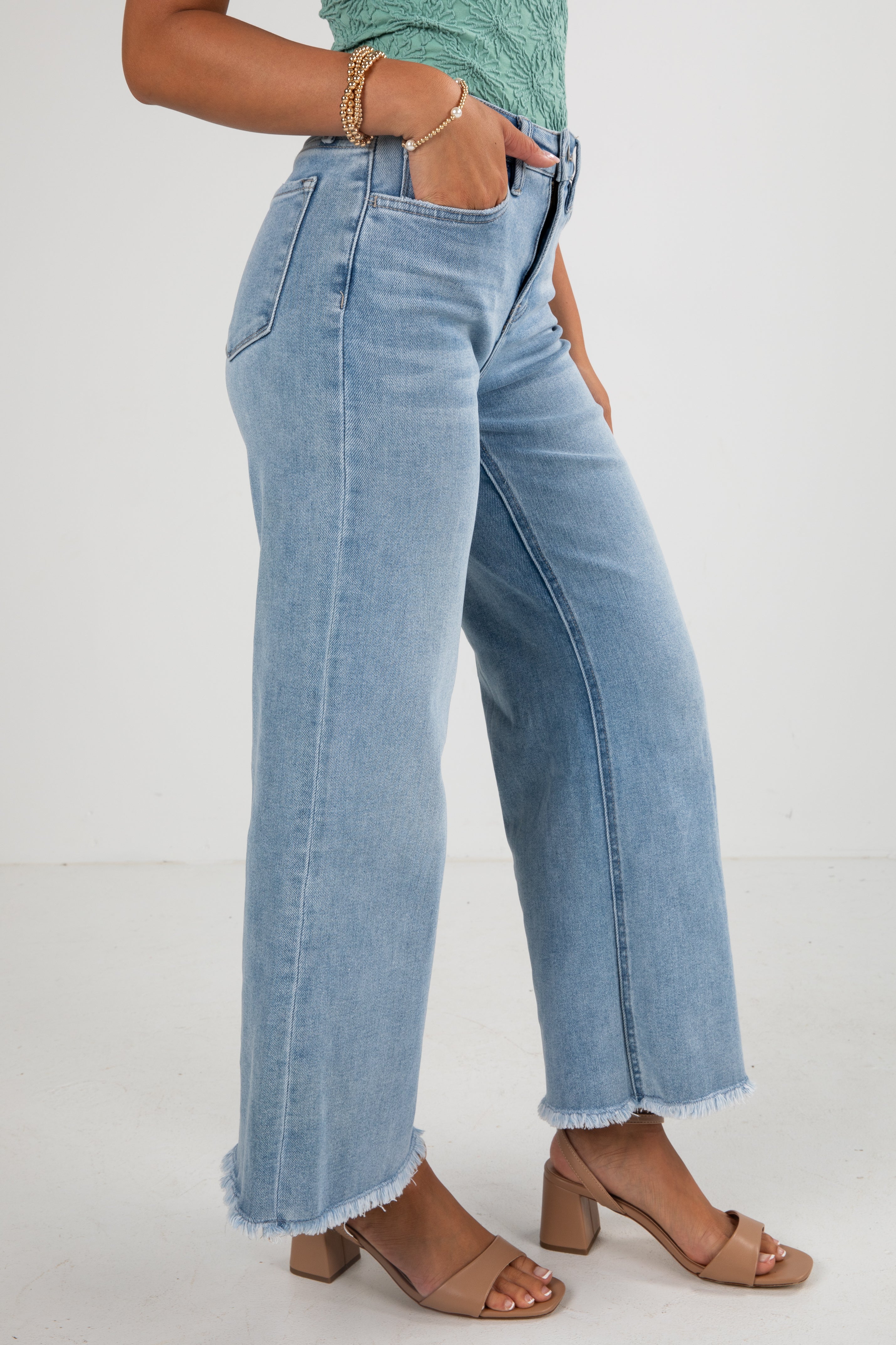 Person wearing light blue jeans on a white background