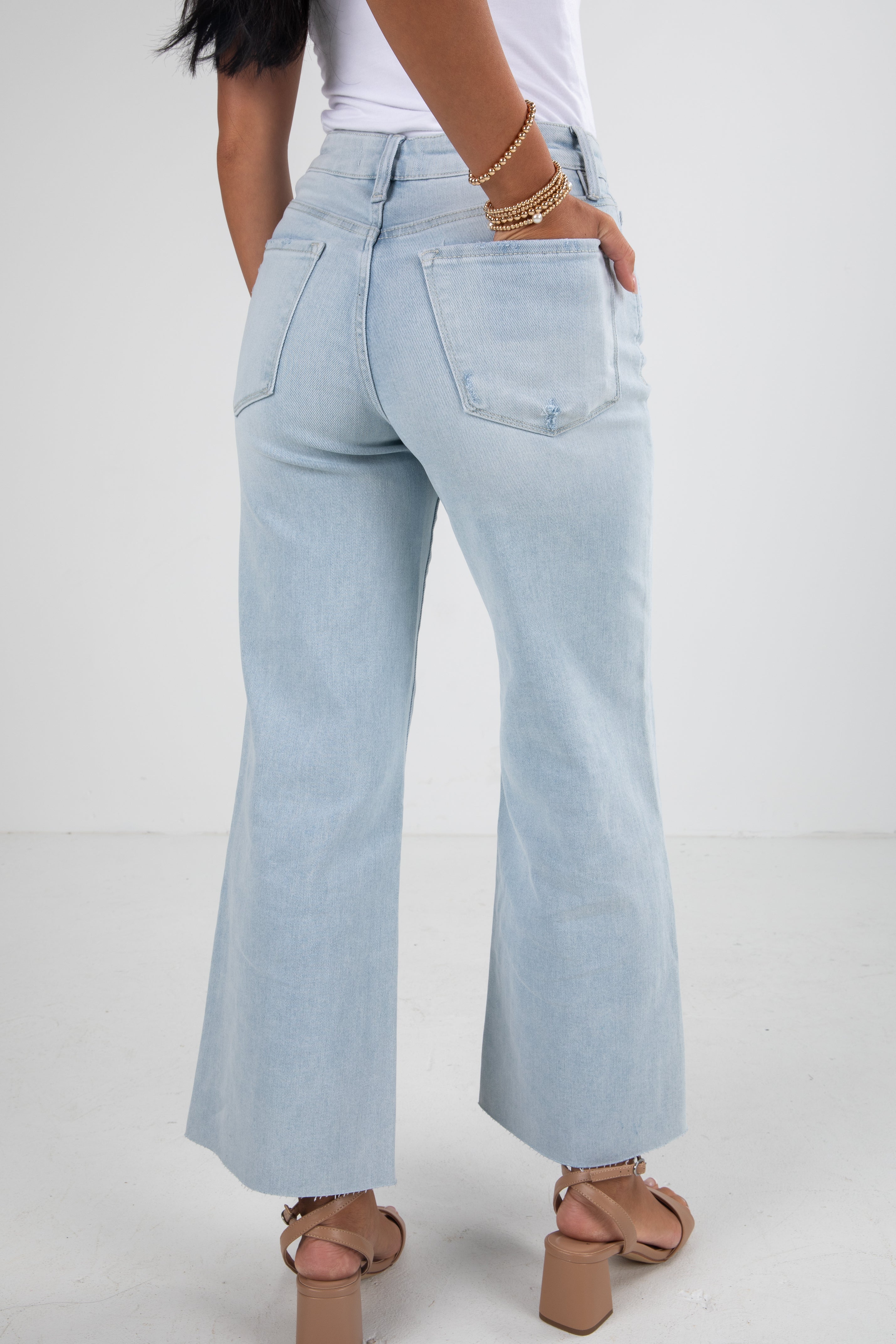 Light blue jeans worn by a person on a white background