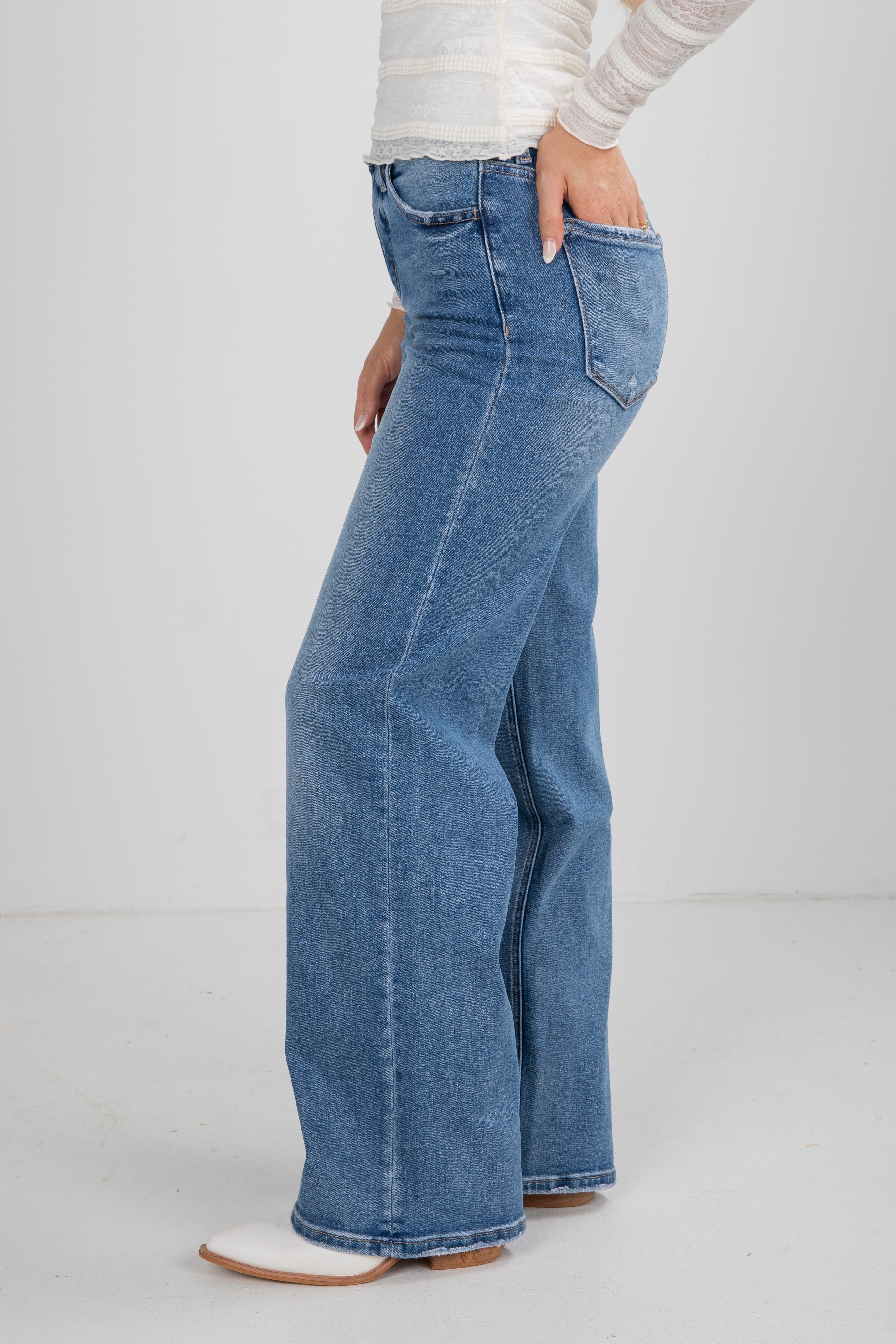 Blue jeans worn by a person on a white background