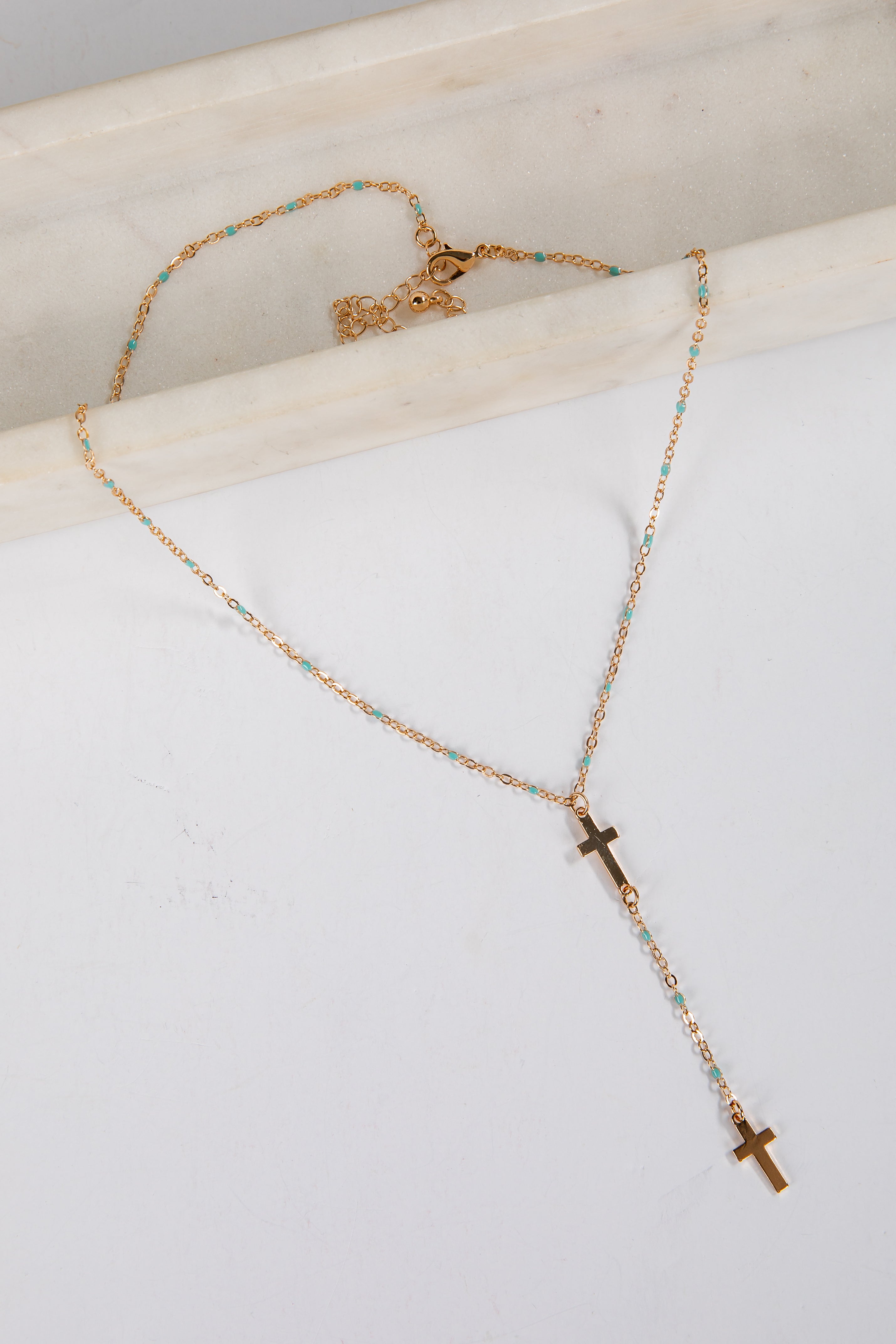 Necklace with cross pendants on a white surface