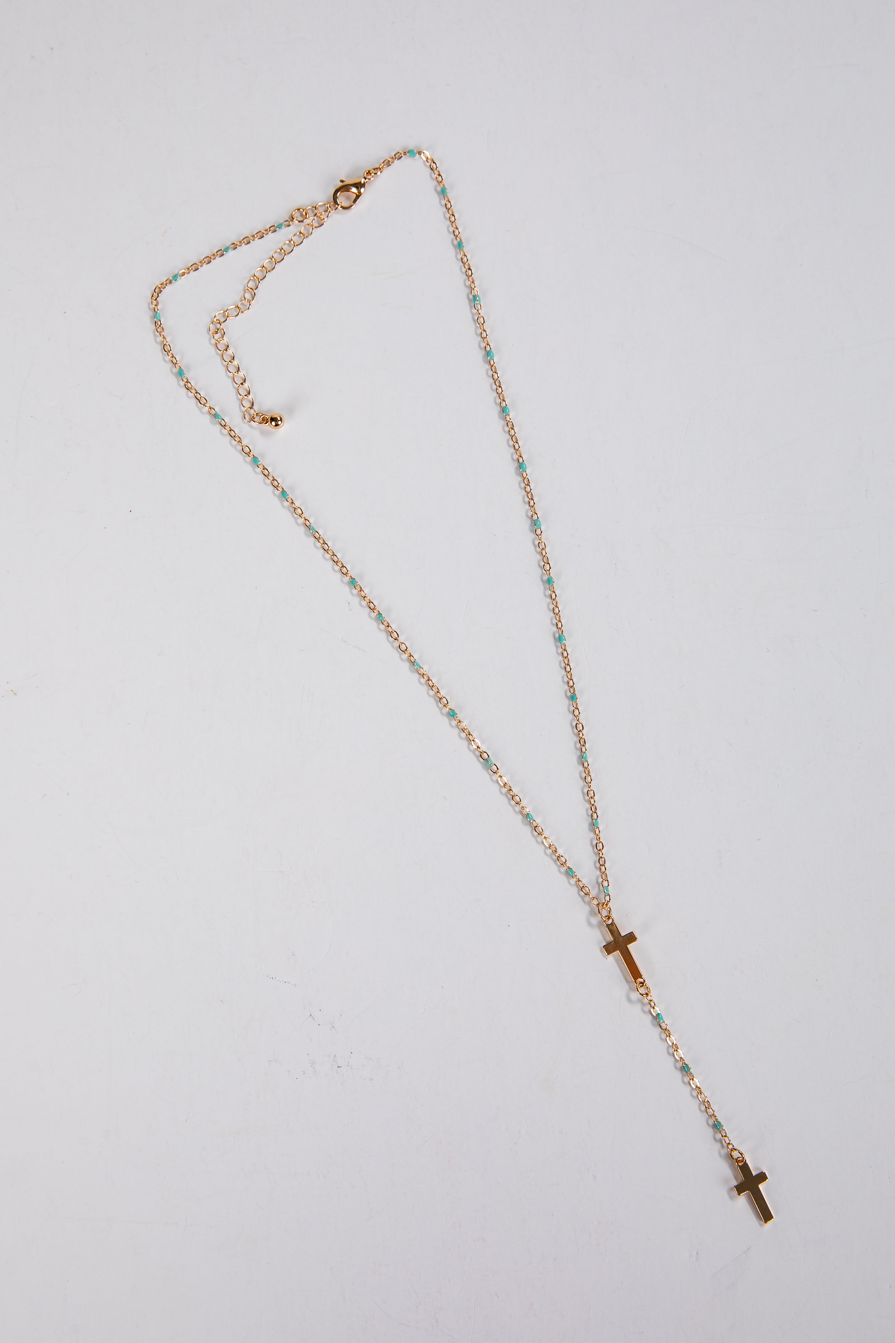 Necklace with a cross pendant on a light gray background