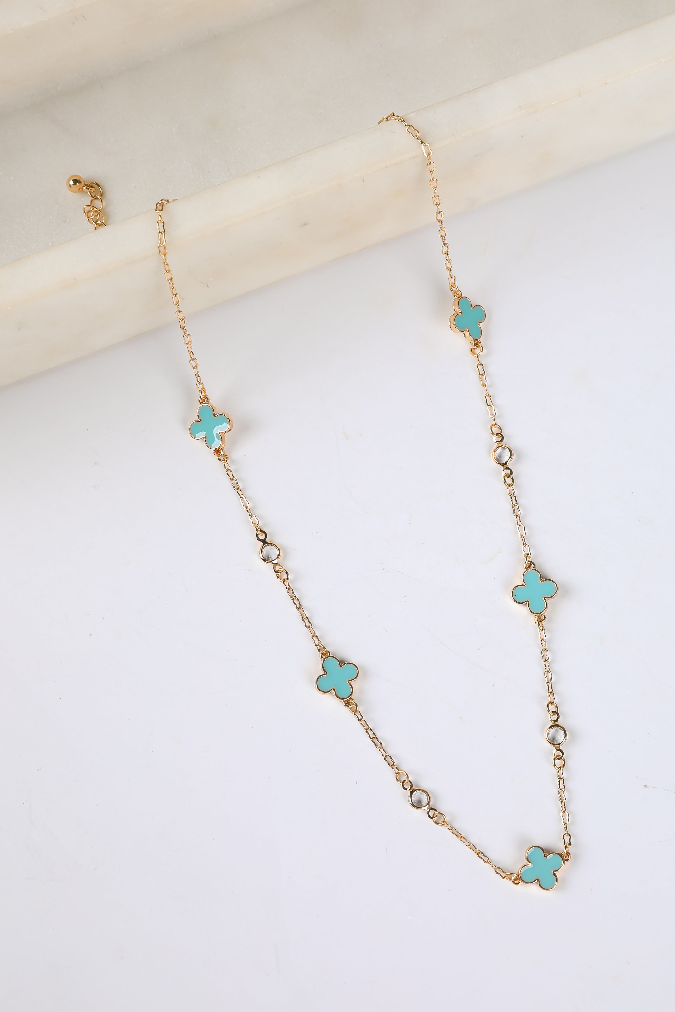 Necklace with turquoise flower-shaped pendants on a white background