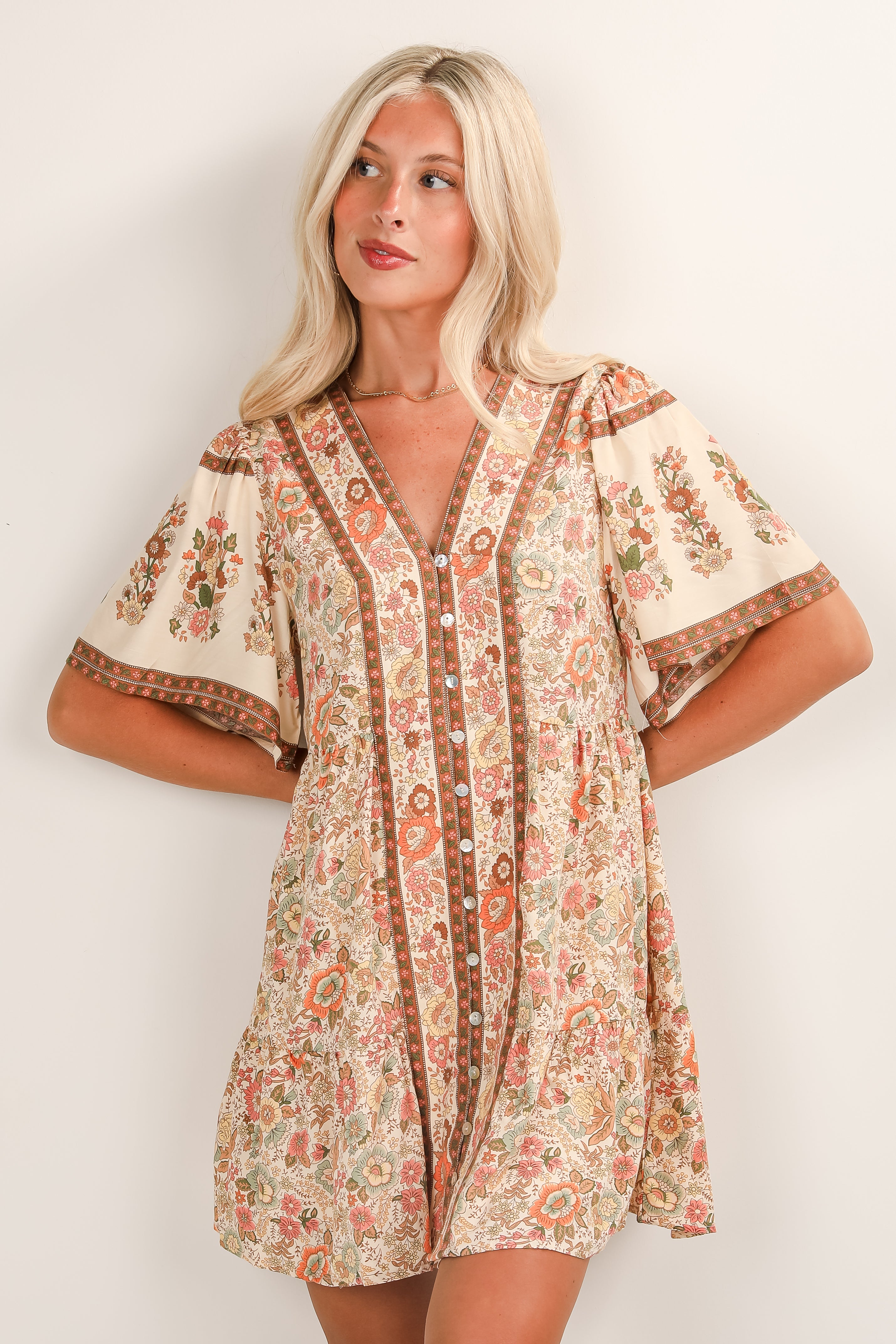 Woman wearing a floral patterned dress against a white background