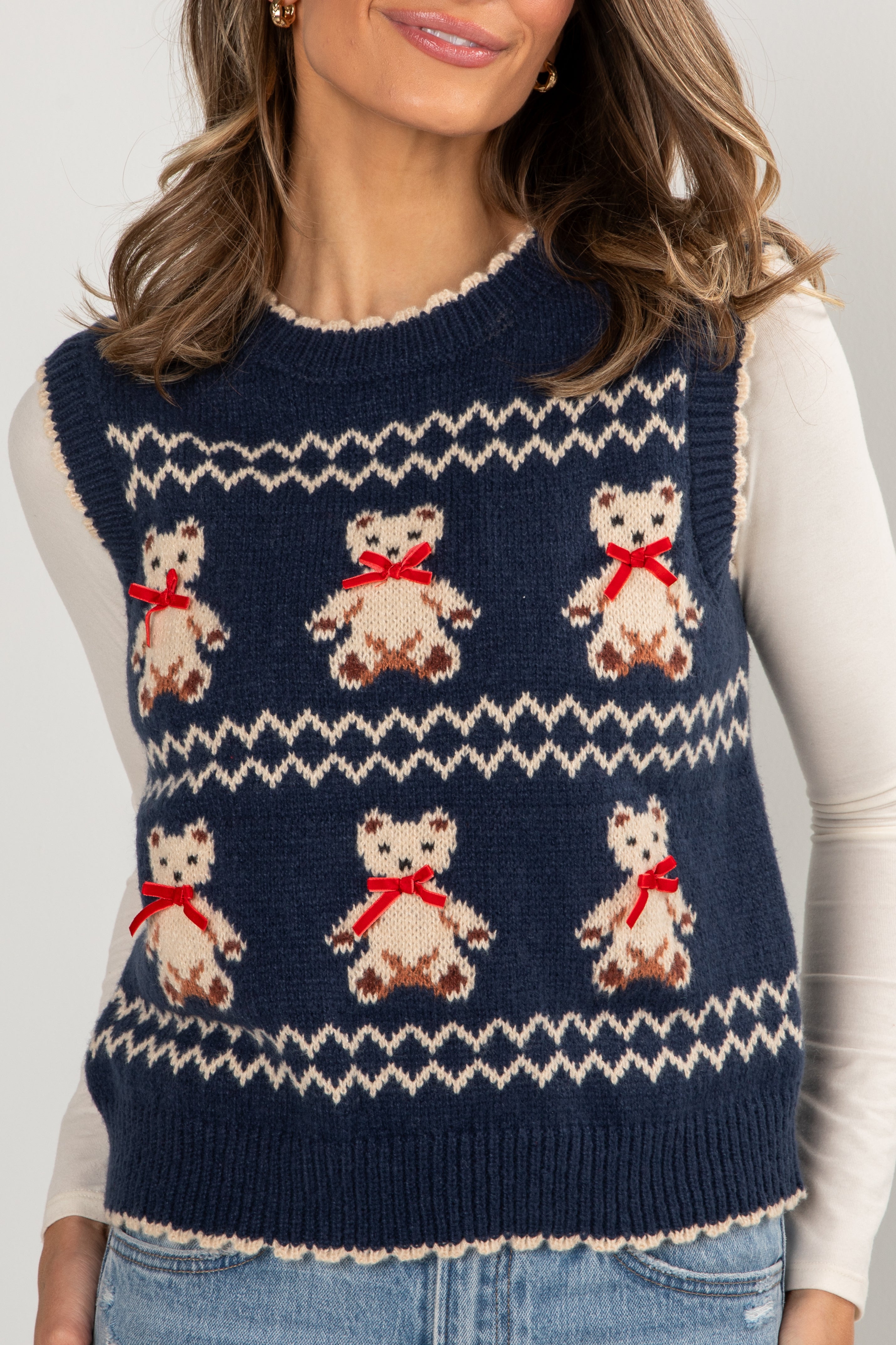 Navy blue knitted vest with teddy bear pattern worn by a person