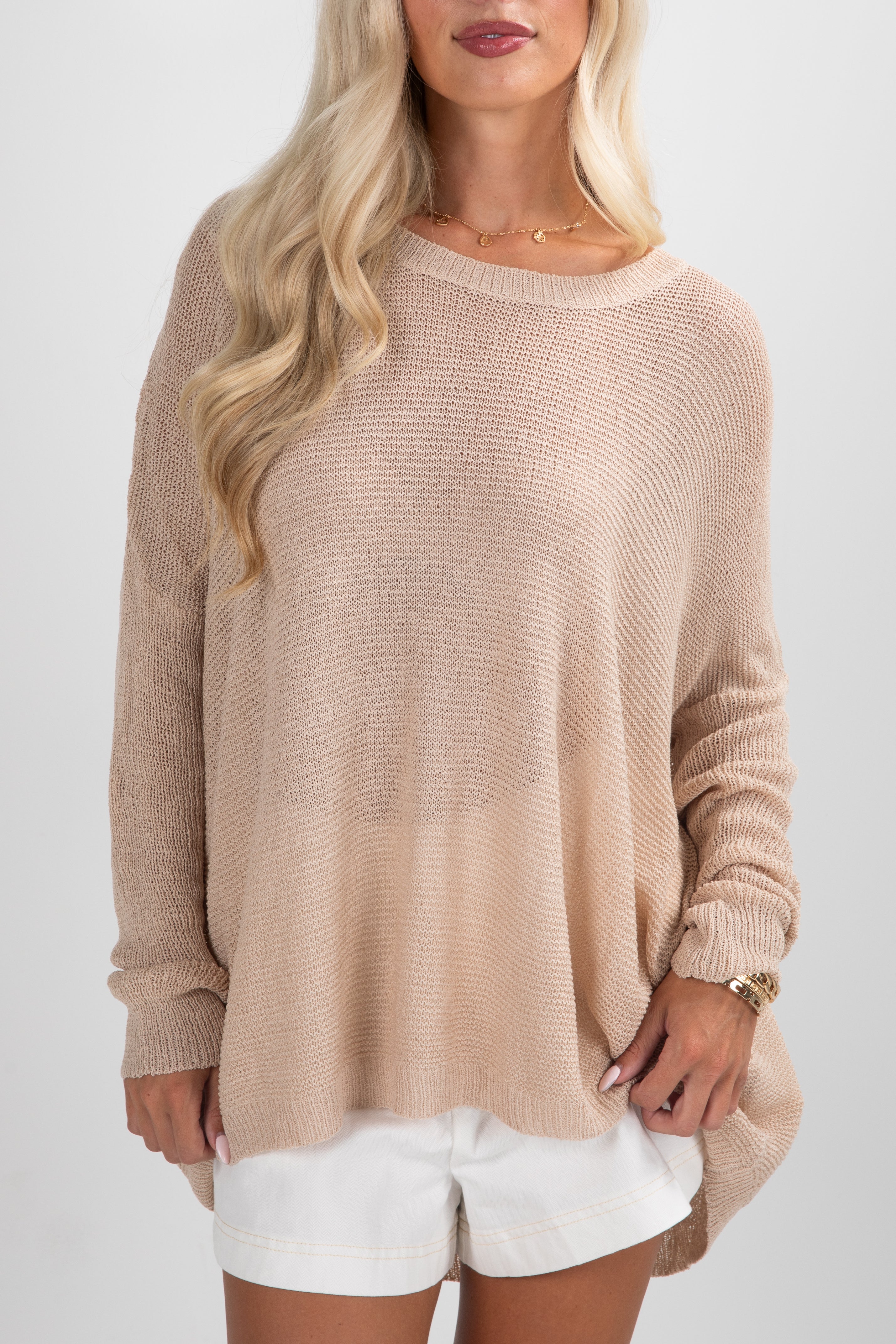 Beige sweater worn by a person on a white background
