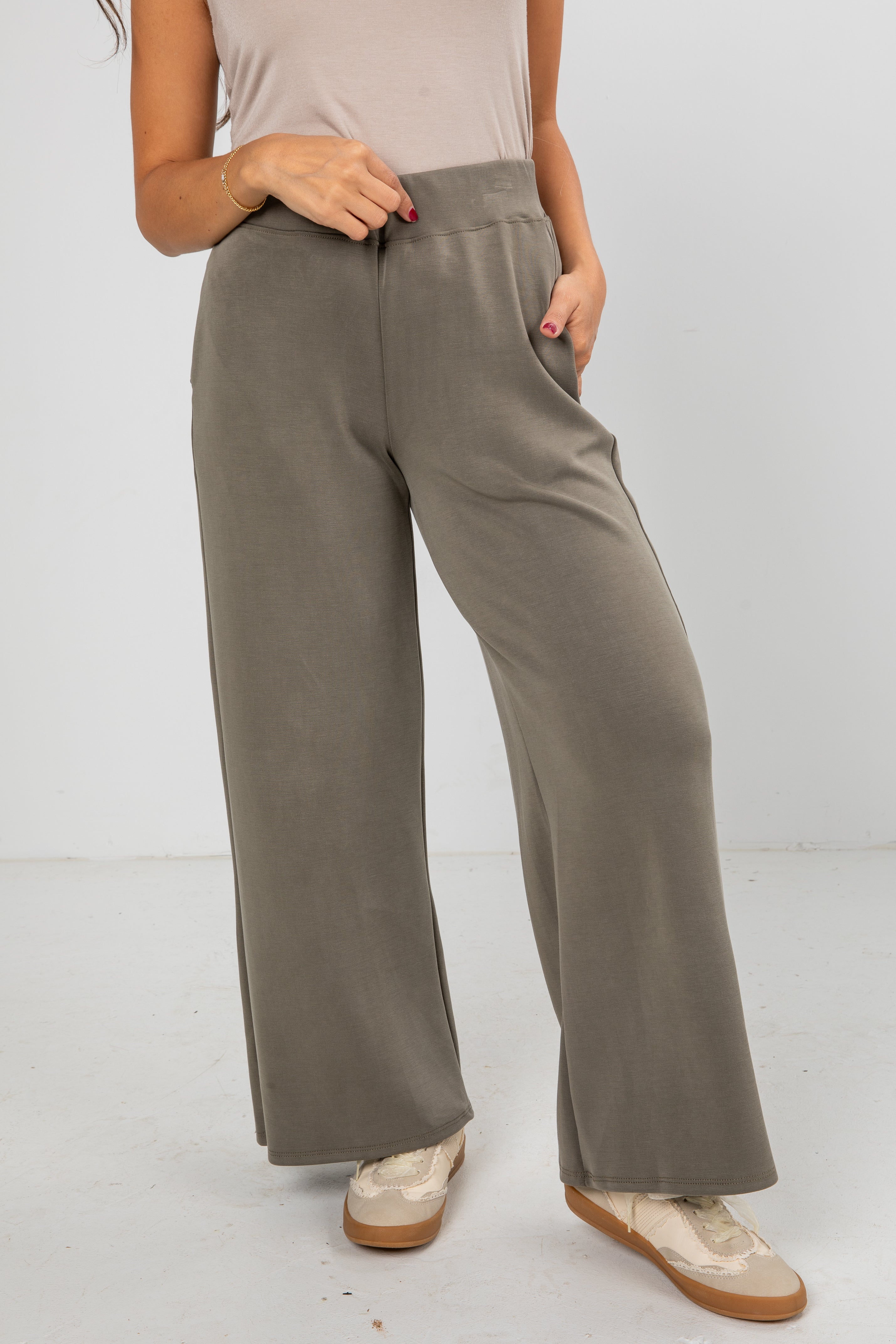 Person wearing gray wide-leg pants on a white background