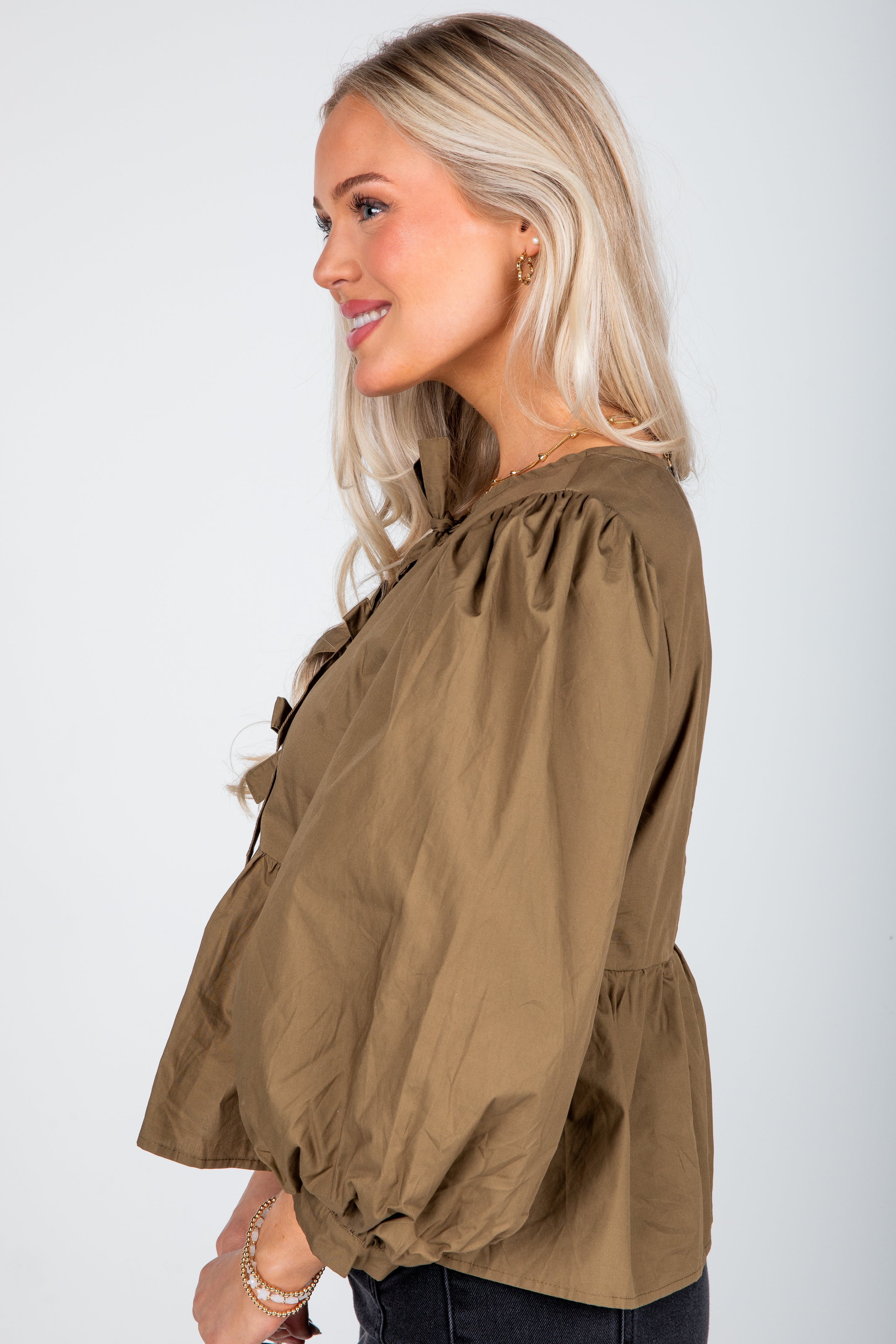 Woman wearing a brown blouse with a white background