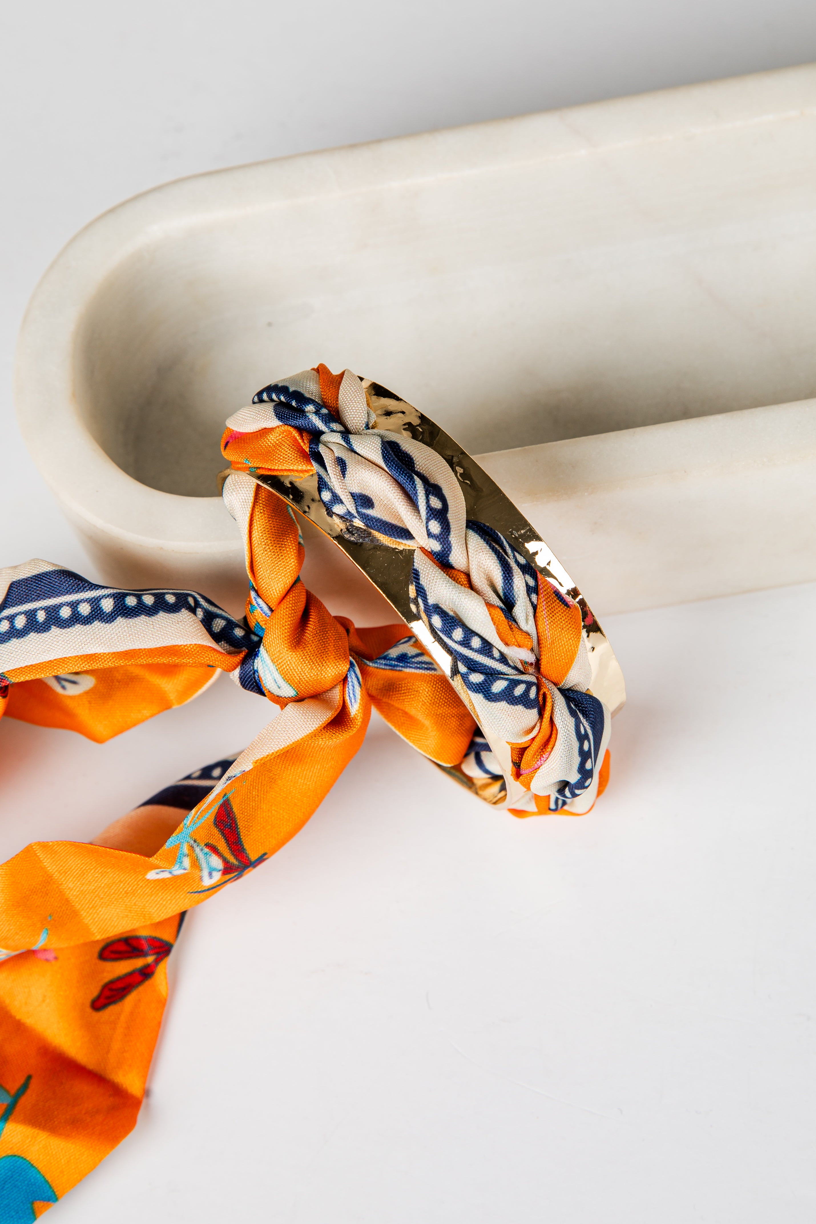 Scarf with geometric pattern draped over a marble surface