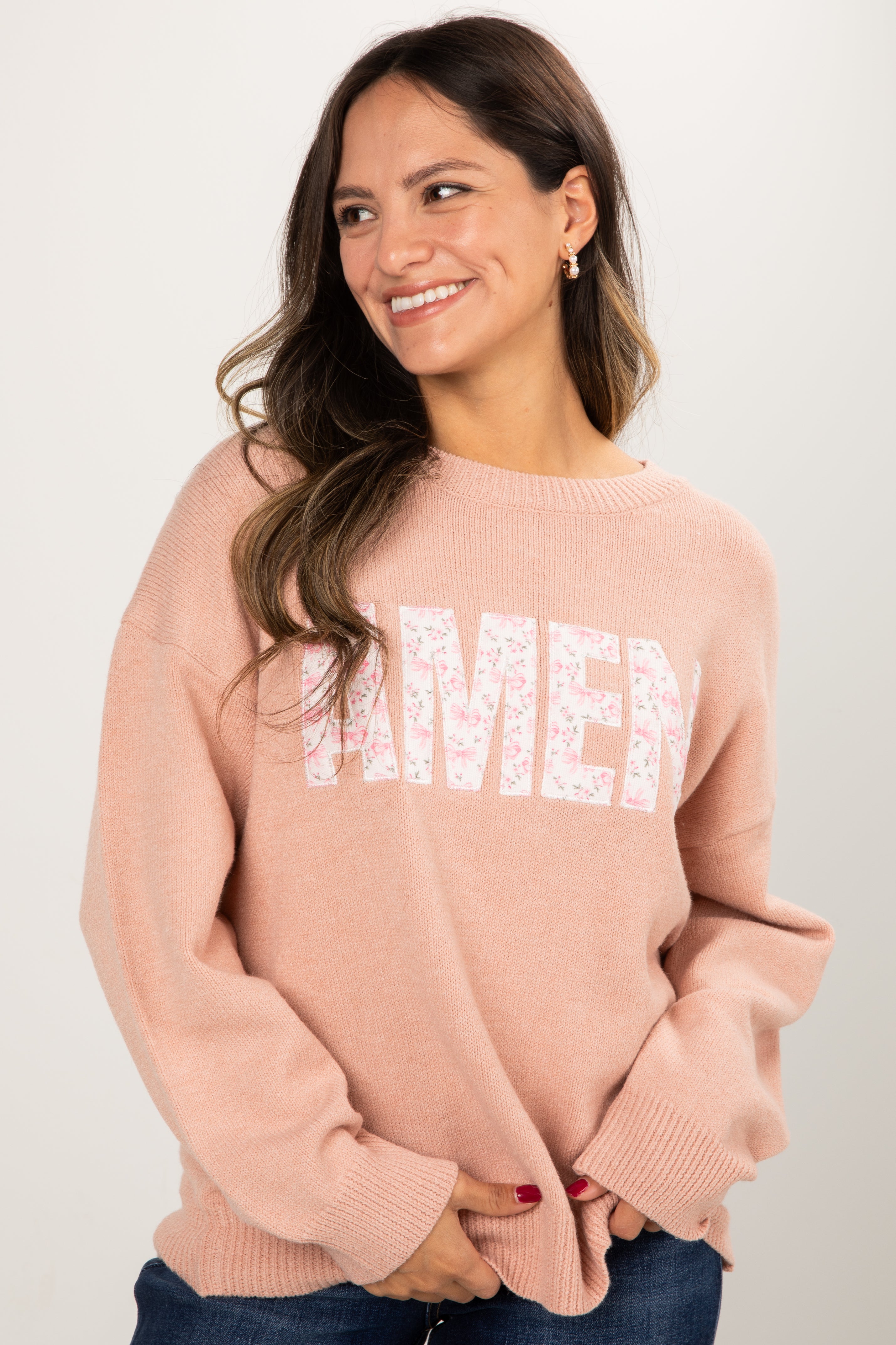 Woman wearing a pink sweater with &