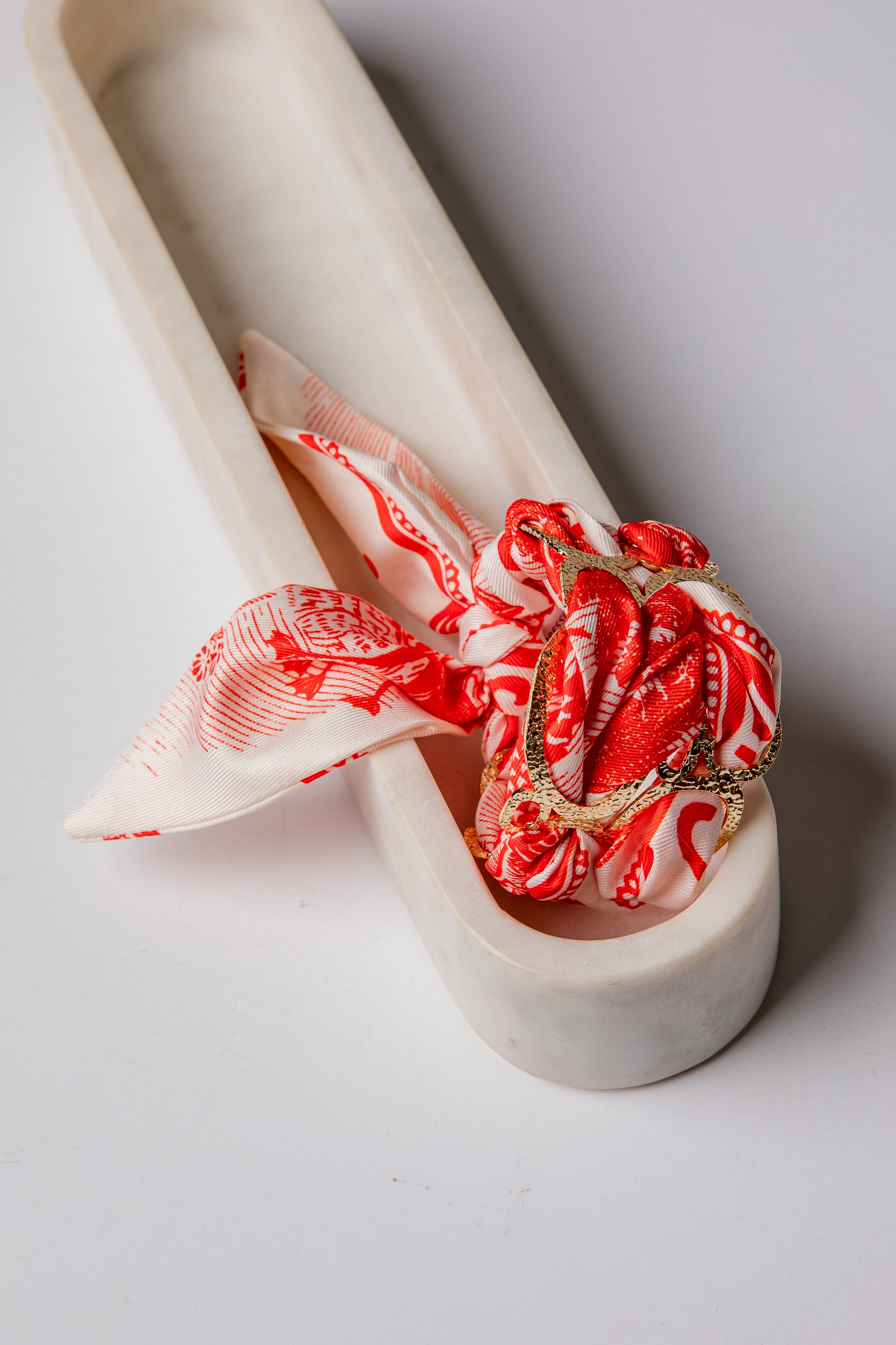 Decorative ring with red and white pattern on a white ceramic stand