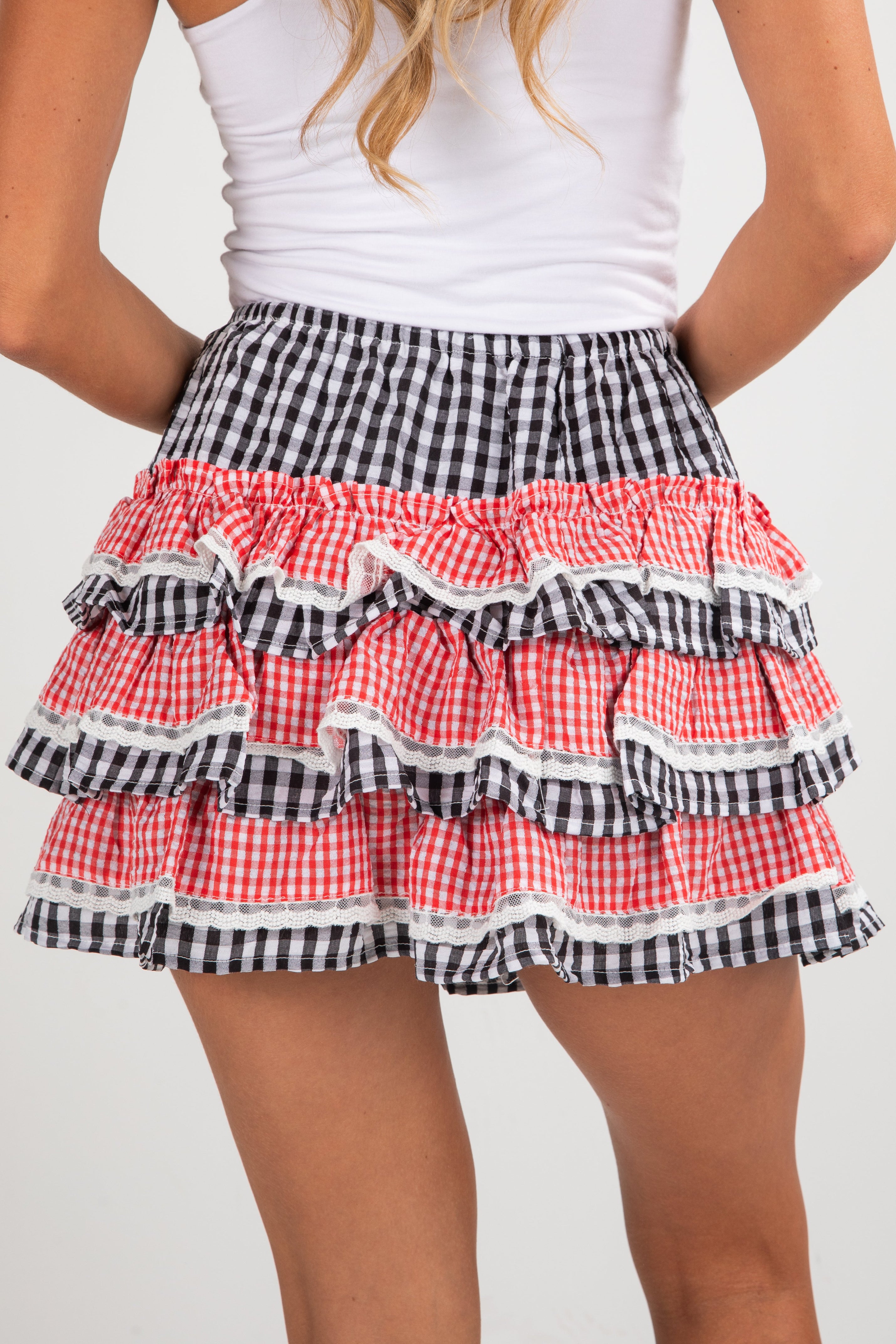 Checkered ruffled skirt with red and black pattern on a plain background
