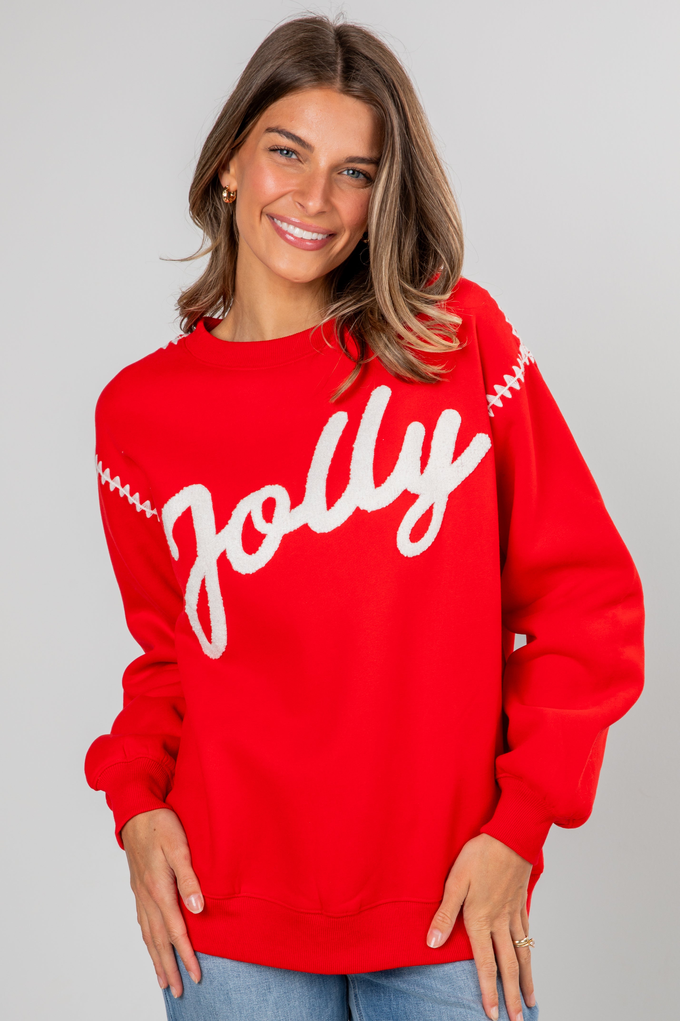 Woman wearing a red sweater with &