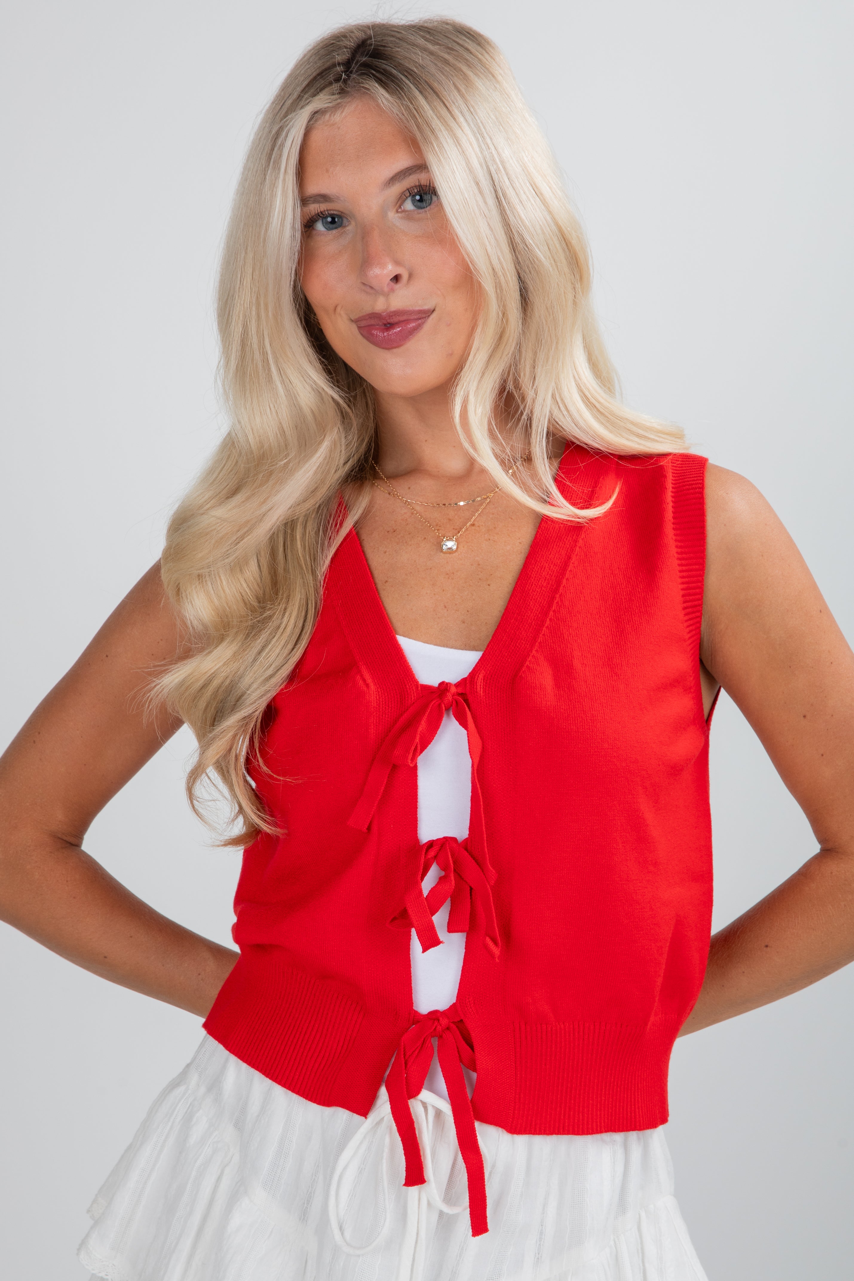 Woman wearing a red sleeveless top with a white background