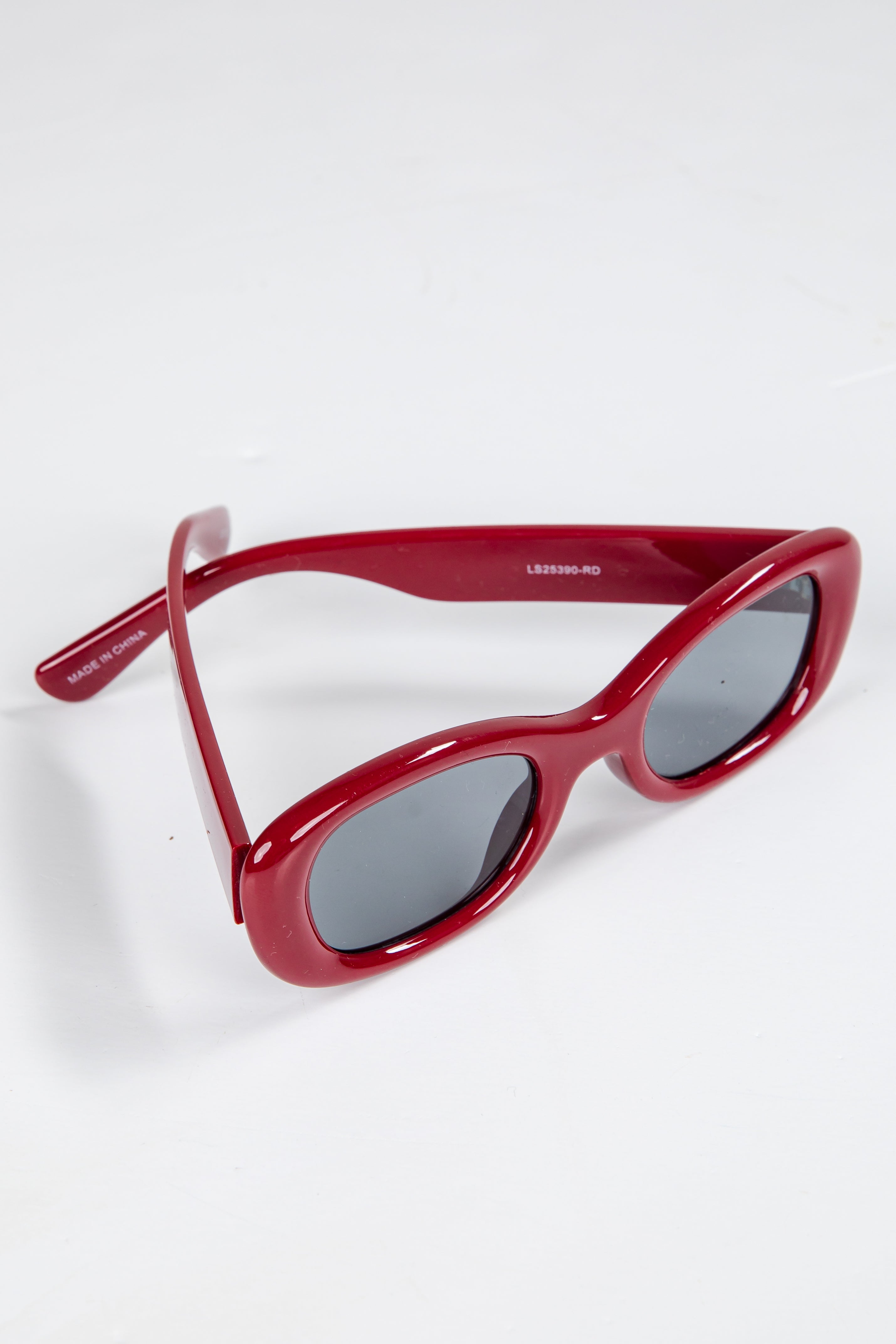 Red sunglasses with dark lenses on a white background