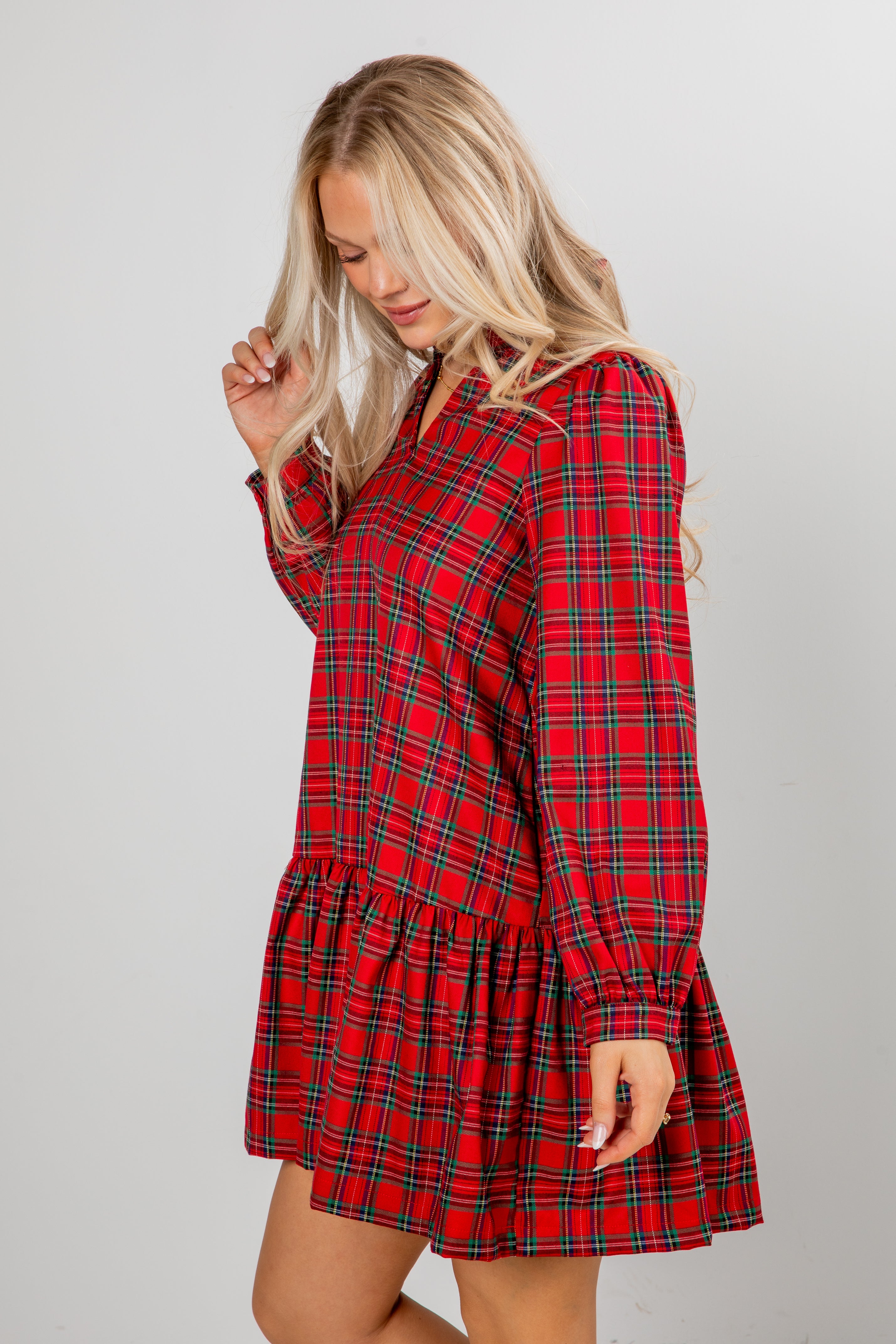 Woman wearing a red plaid dress against a gray background