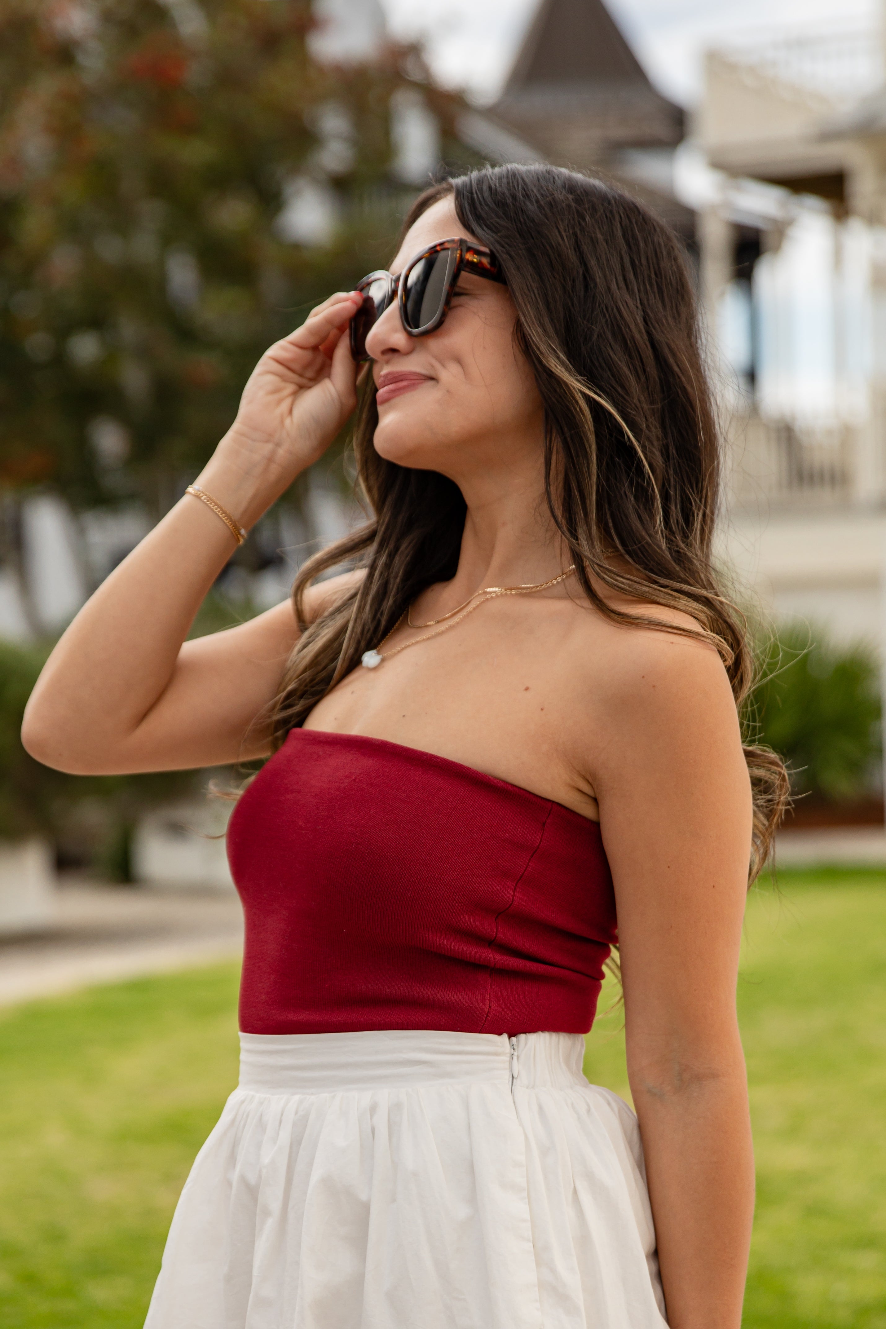 Woman wearing a red top and white skirt outdoors