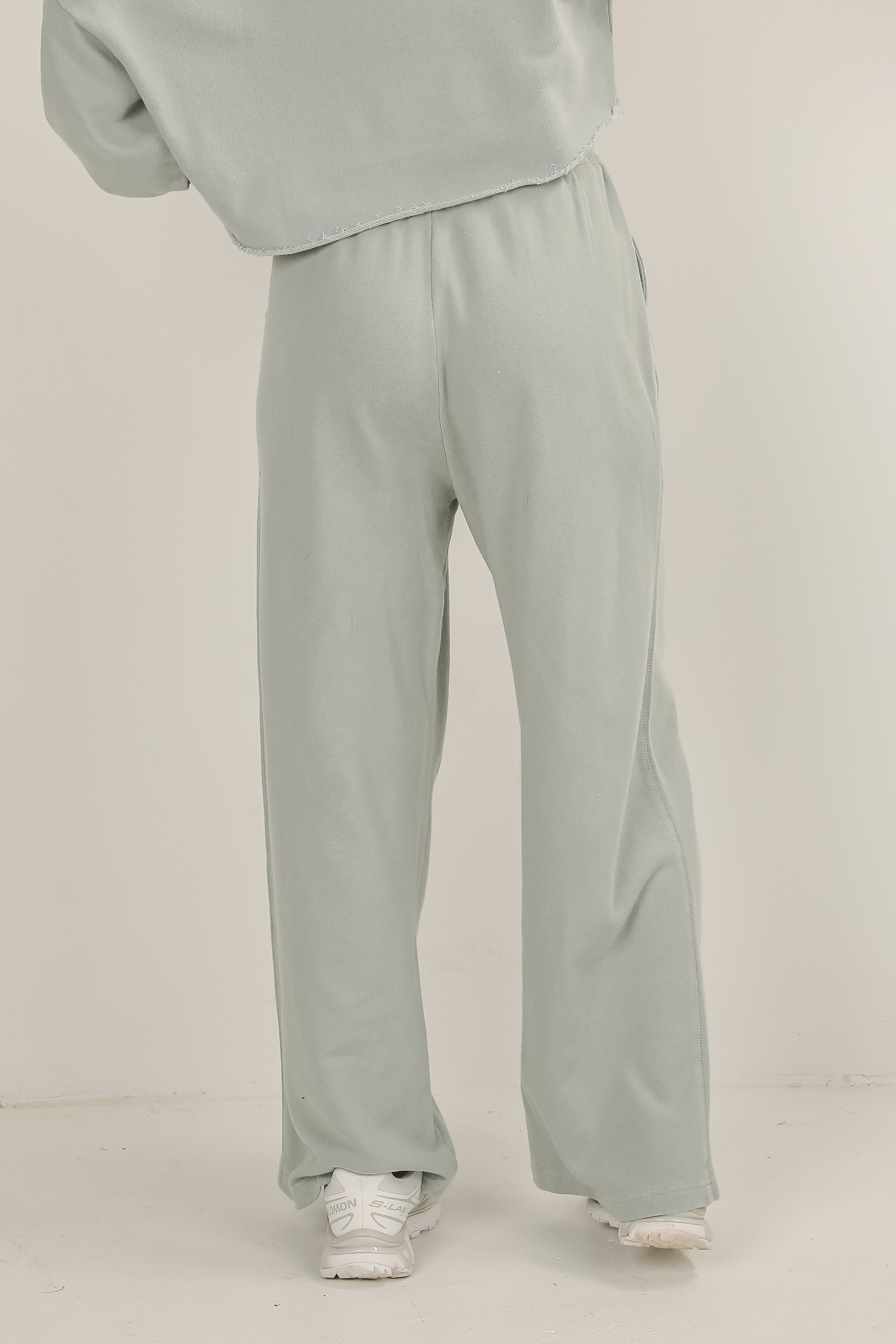 Person wearing light gray sweatpants on a plain background