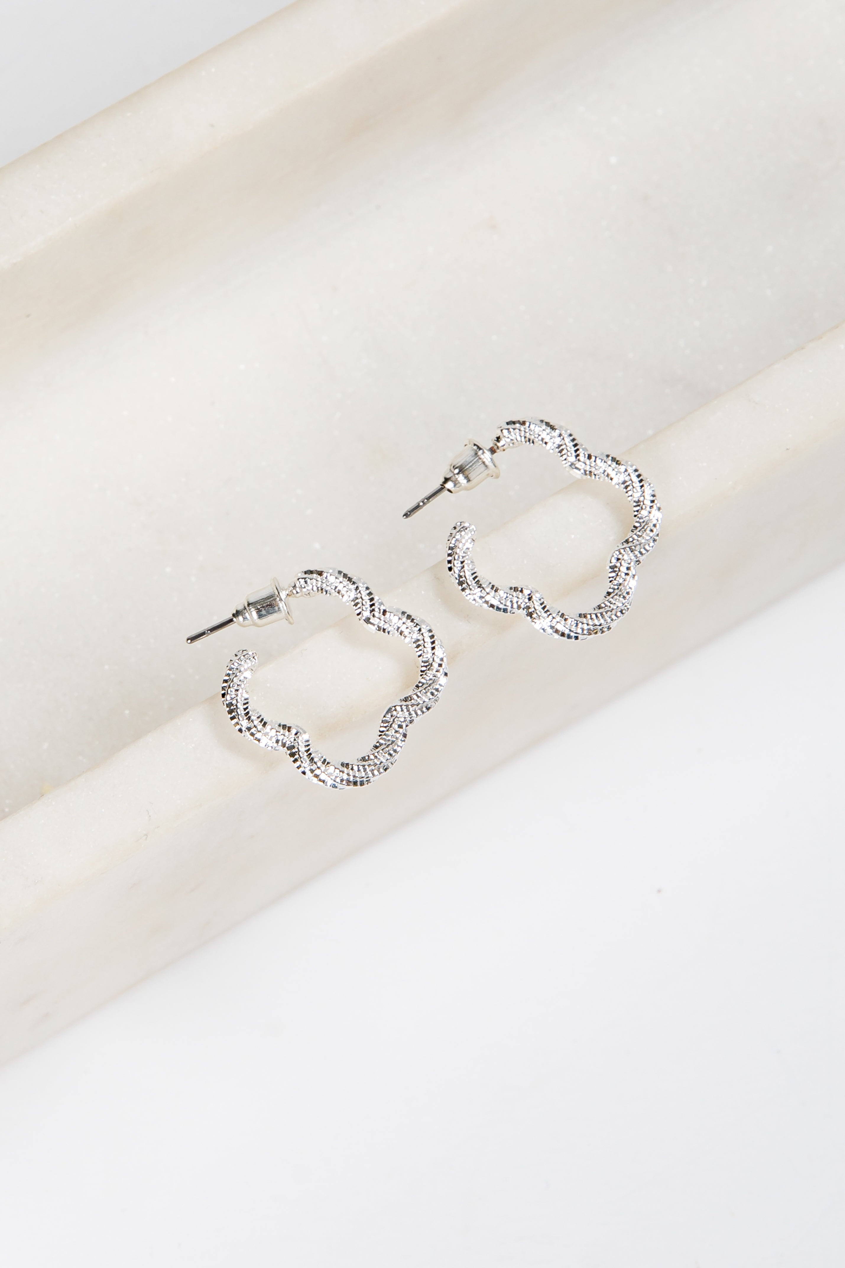 Silver hoop earrings on a white surface