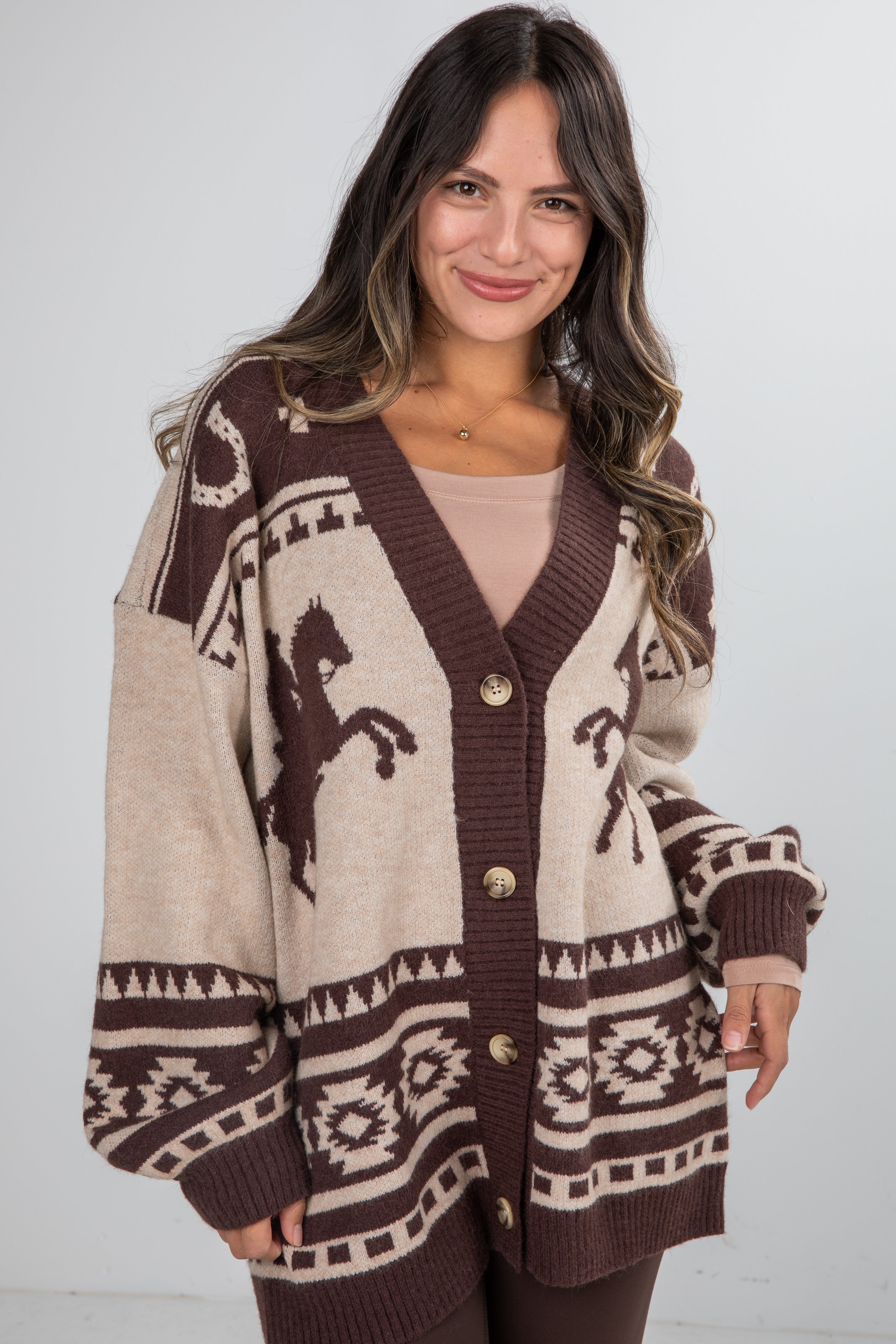Woman wearing a patterned cardigan with horse design on a white background