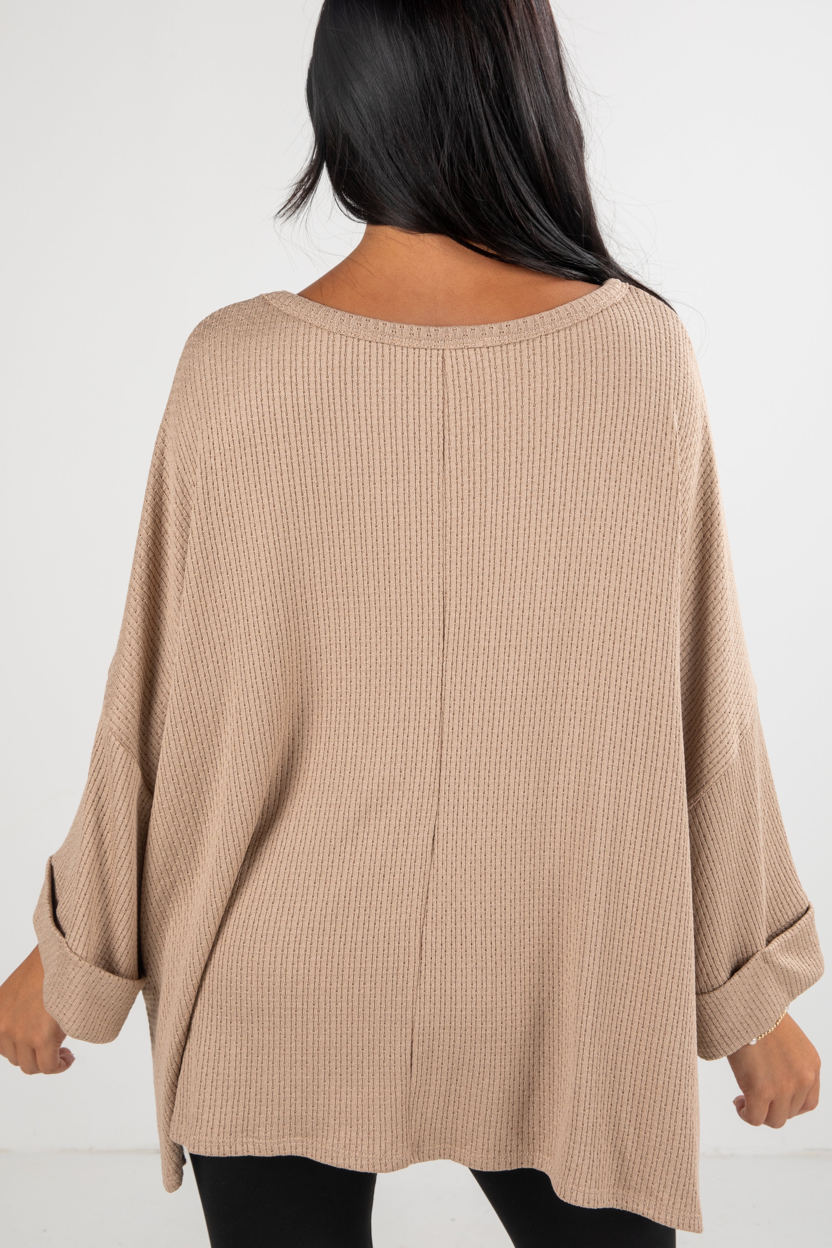 Beige oversized sweater worn by a person on a white background